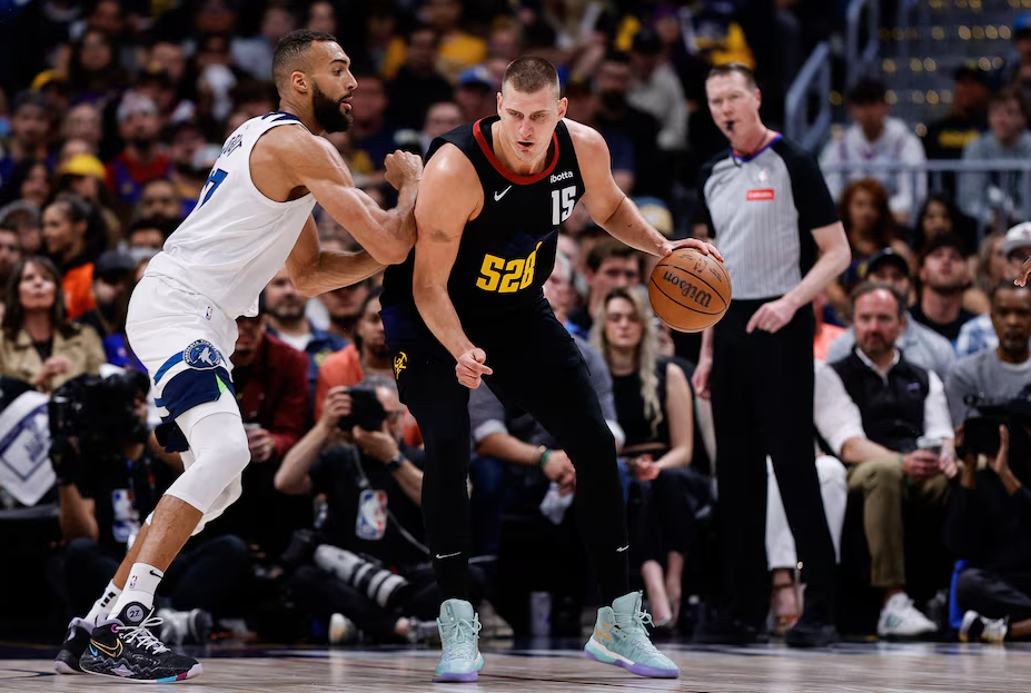 Denver Nuggets center Nikola Jokic (15) controls the ball as Minnesota Timberwolves center Rudy Gobert (27) guards in the first quarter during game five of the second round for the 2024 NBA playoffs at Ball Arena in Denver, Colorado, May 14, 2024.