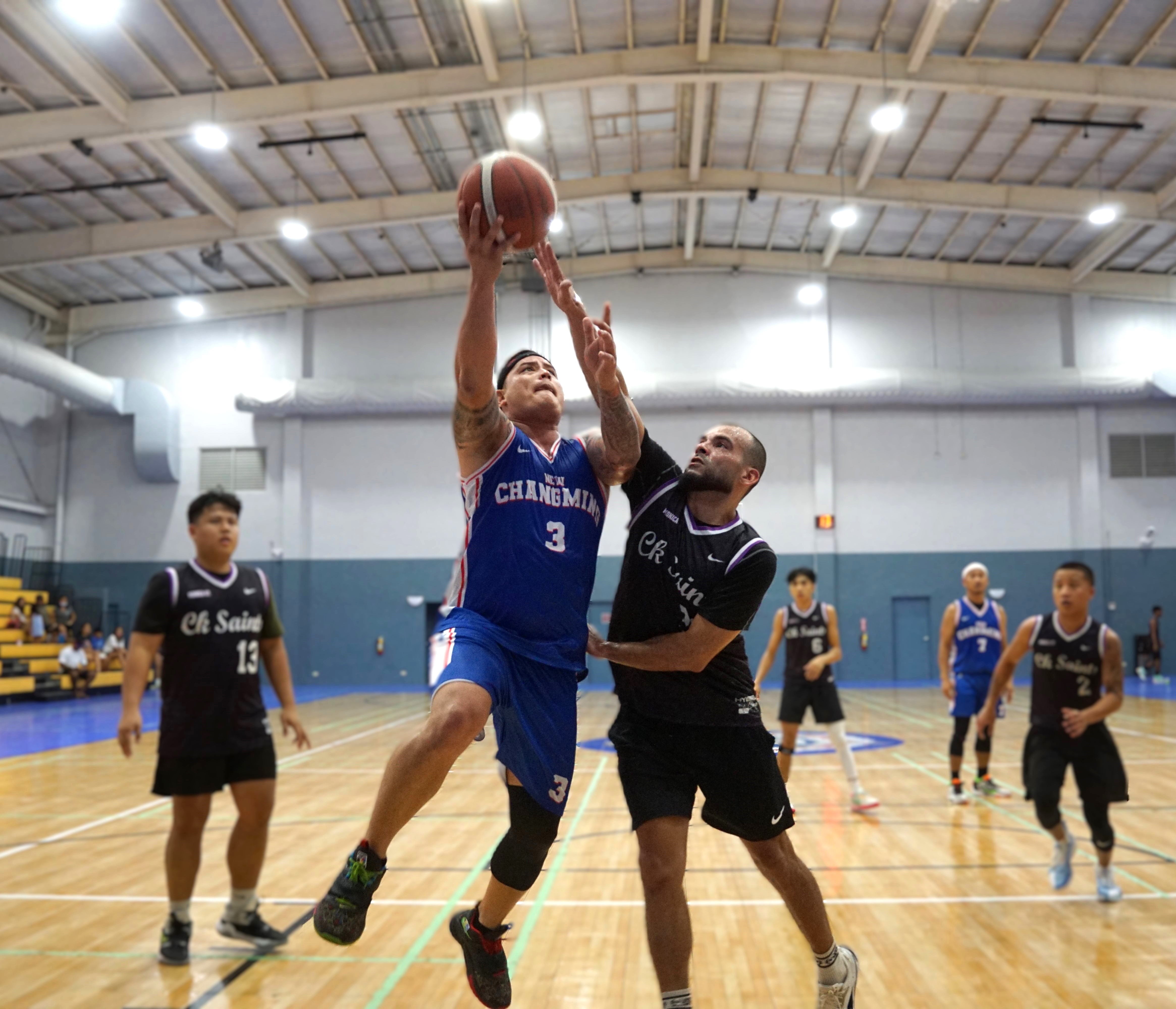 New Changming's Juan Camacho takes the shot over the Saints’ Eli Aughenbaugh during a Michelob Ultra Cup 2024 game at the Ada gym on Saturday.