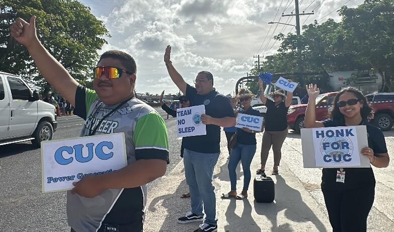 CUC employees wave at motorists.