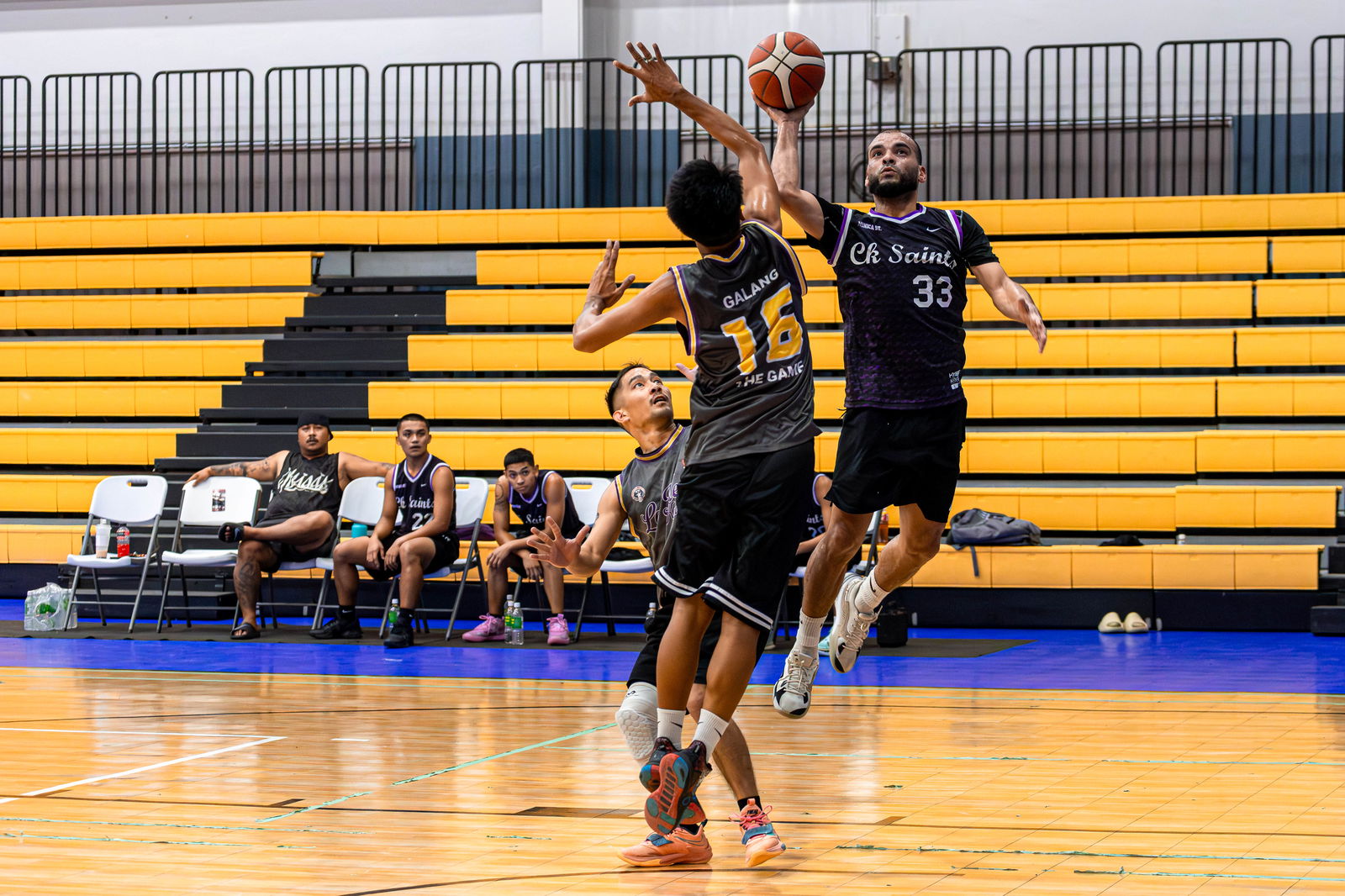 The Saints' Eli Aughenbaugh attempts a running floater over Lamesa Kusina's JC Galang during a quarterfinal game of the Michelob Ultra Cup 2024 at the Ada gym on Tuesday.