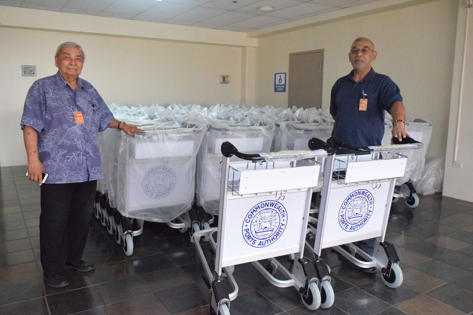 Commonwealth Ports Authority Executive Director Leo Tudela, left, and Francisco C. Ada/Saipan International Airport Manager Frank Duenas pose with brand new baggage carts in the departure area.