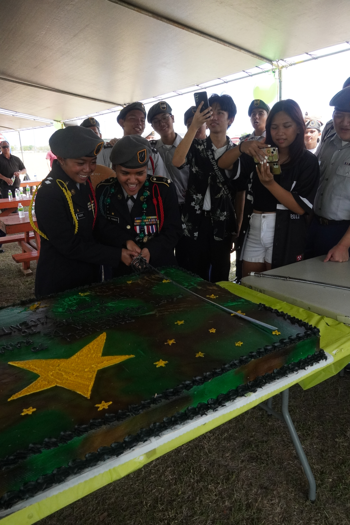 The outgoing and incoming commanders cut a cake with a saber.