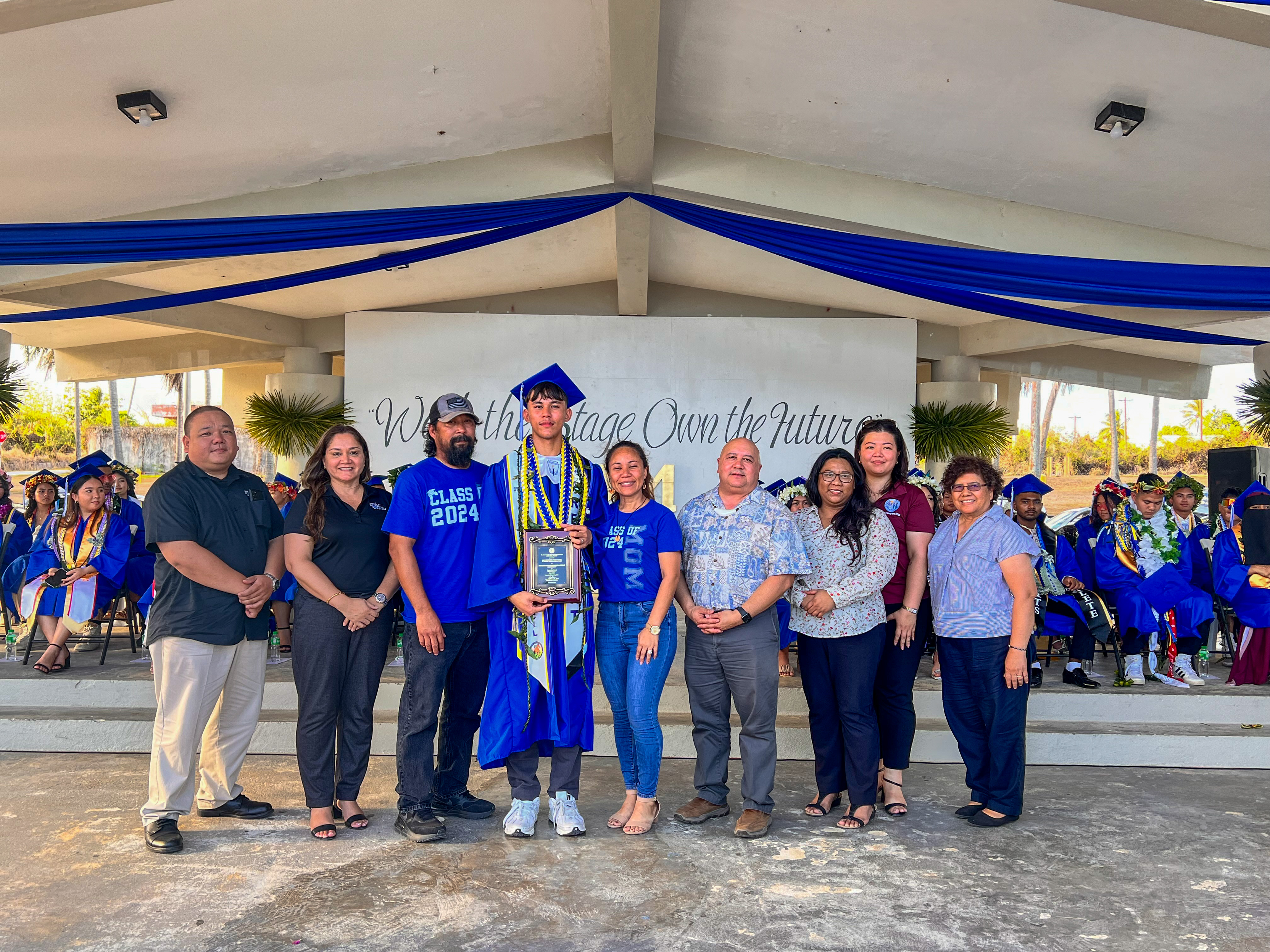 The Commissioner of Education Academic Excellence Award was presented to Romaldo Hofschneider Santos Jr., the class salutatorian, by Commissioner of Education Dr. Lawrence F. Camacho and other key PSS officials: Associate Commissioner for Administrative Services Eric Magofna, Special Education State Director Donna Flores, Federal Programs Officer Jacqueline Che, Instructional Technology and Distance Education Director Lorraine Catienza and Senior Director for Instructional Services Jackie Quitugua.