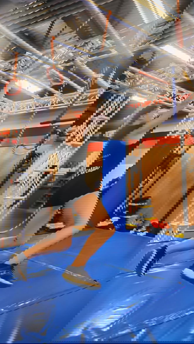 An athlete hangs on to hanging rings in a Sindalu Ninja Games demonstration.