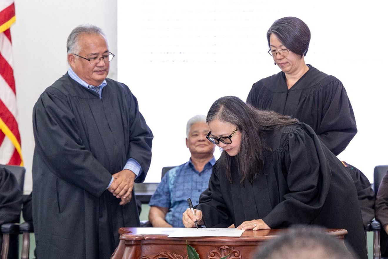 Superior Judge Lillian A. Tenorio signs the Treatment Court Month Proclamation while Presiding Judge Roberto C. Naraja and Judge Teresa K. Kim-Tenorio wait to add their signatures, as well at the Guma’ Hustisia on April 26, 2024. 