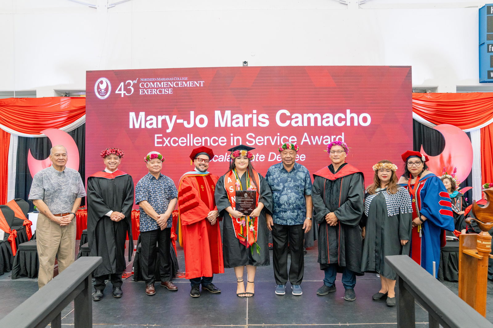 Mary-Jo Maris Jack Camacho, who graduated cum laude with a Bachelor of Science in Business Management, was honored with the Excellence in Service Award at Northern Marianas College’s 43rd Commencement Exercise on May 17, 2024, at the Marianas High School Gymnasium. Pictured with Camacho, from left to right, are keynote speaker U.S. Congressman Gregorio Kilili Camacho Sablan, NMC Vice President for Administration and Advancement Frankie Eliptico, CNMI Gov. Arnold I. Palacios, NMC President Galvin Deleon Guerrero, EdD, CNMI Lt. Gov. David M. Apatang, NMC Board of Regents Chair Charles Cepeda, NMC Dean of Student Support Services Charlotte Cepeda, and NMC Acting Dean of Academic Programs and Services Dr. Barbara Hunter.