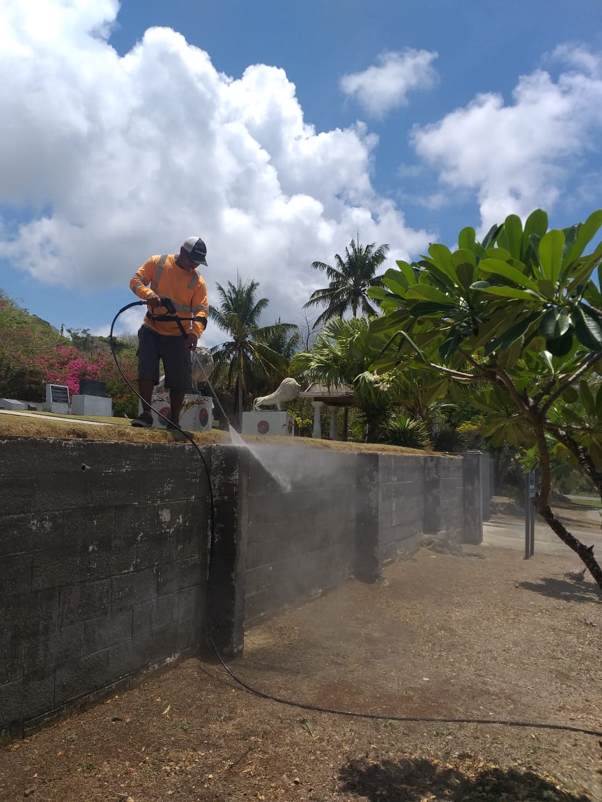 An employee of LJ Lawn Care water blasts at the Korean Memorial as part of the company's community service during May Marianas Tourism Month to enhance the Korean, Okinawan, and Japanese memorials in Marpi.  The company collaborated with the Marianas Visitors Authority and Women's National Team of the Northern Mariana Islands Football Association on the project.