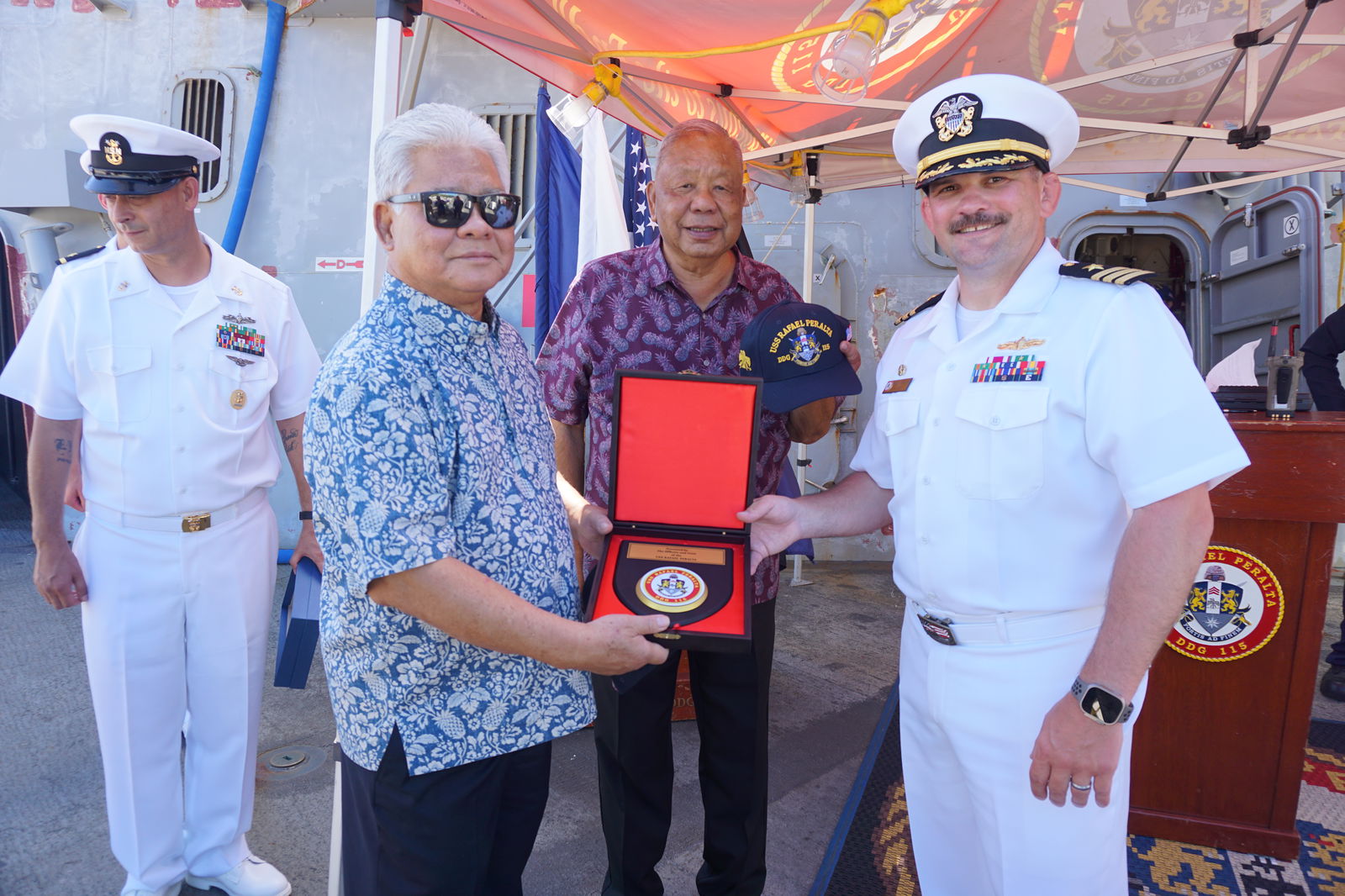 Gov. Arnold I. Palacios and Lt. Gov. David M. Apatang receive a commemorative plaque from Commander Steve Szachta aboard the USS Rafael Peralta on Thursday, June 20. 