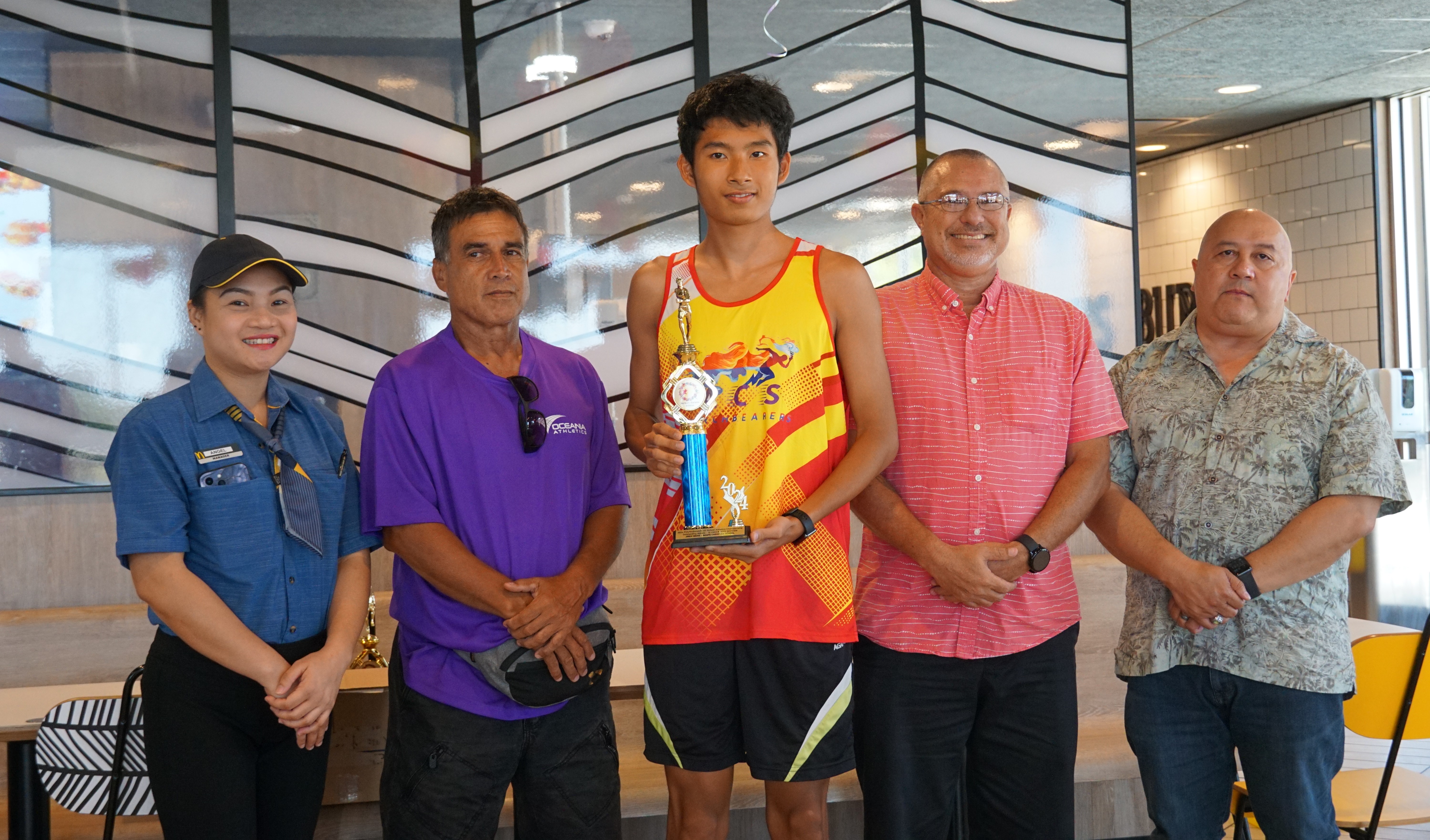 U18 male MVP Jireh Wang, center, poses for a photo with a McDonald's Saipan employee, Northern Marianas Athletics' Elias Rangamar, Board of Education member Greg Borja and Education Commissioner Dr. Lawrence F. Camacho during the McDonald's-PSS All Schools Track and Field (Athletics) SY23-24 awards ceremony at McDonald's Chalan Kiya on Thursday last week.