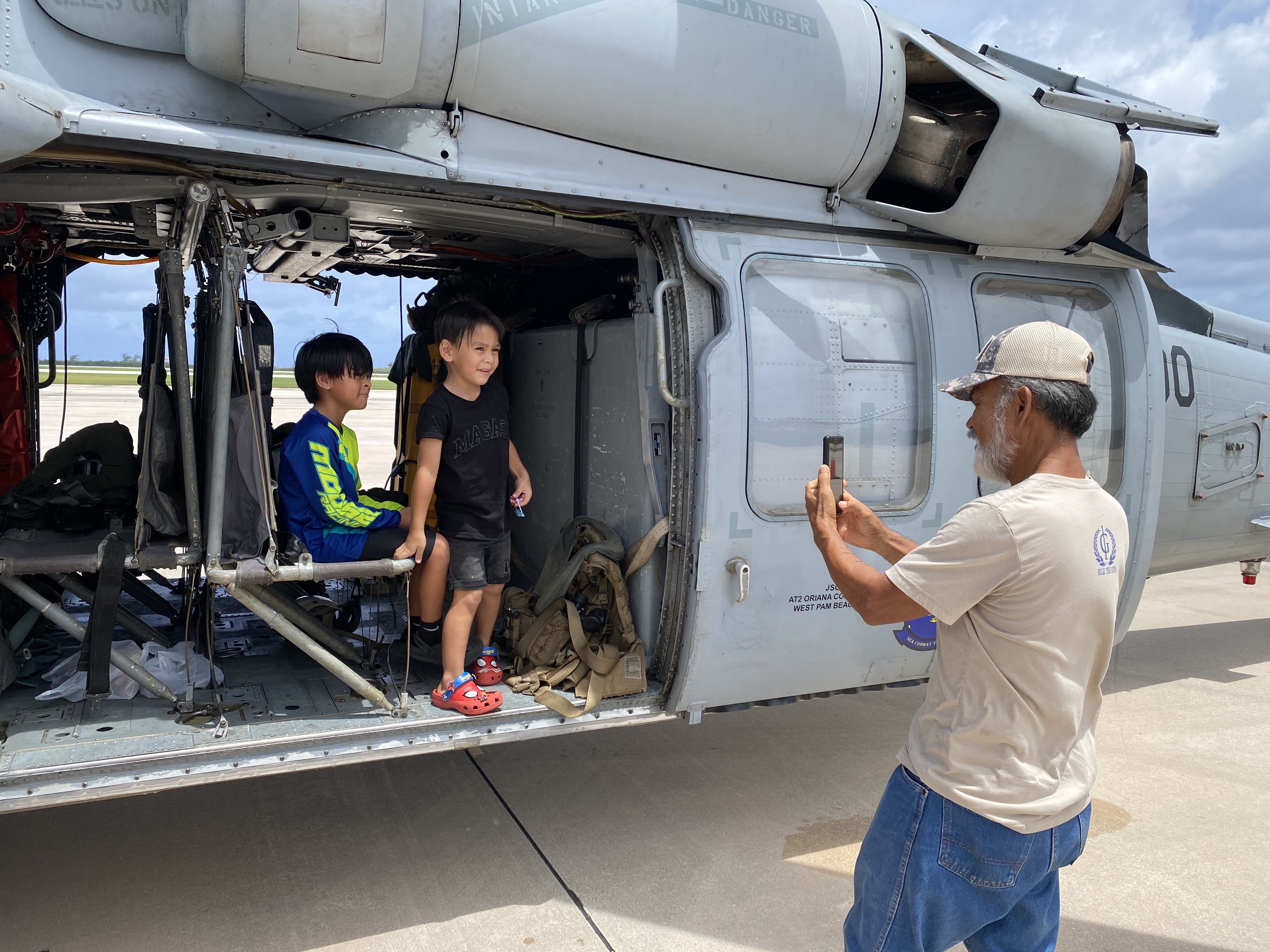 Fabian Indalecio and his grandchildren check out a U.S. Navy MH-60S helicopter that was part of an outreach opportunity on June 26, 2024.