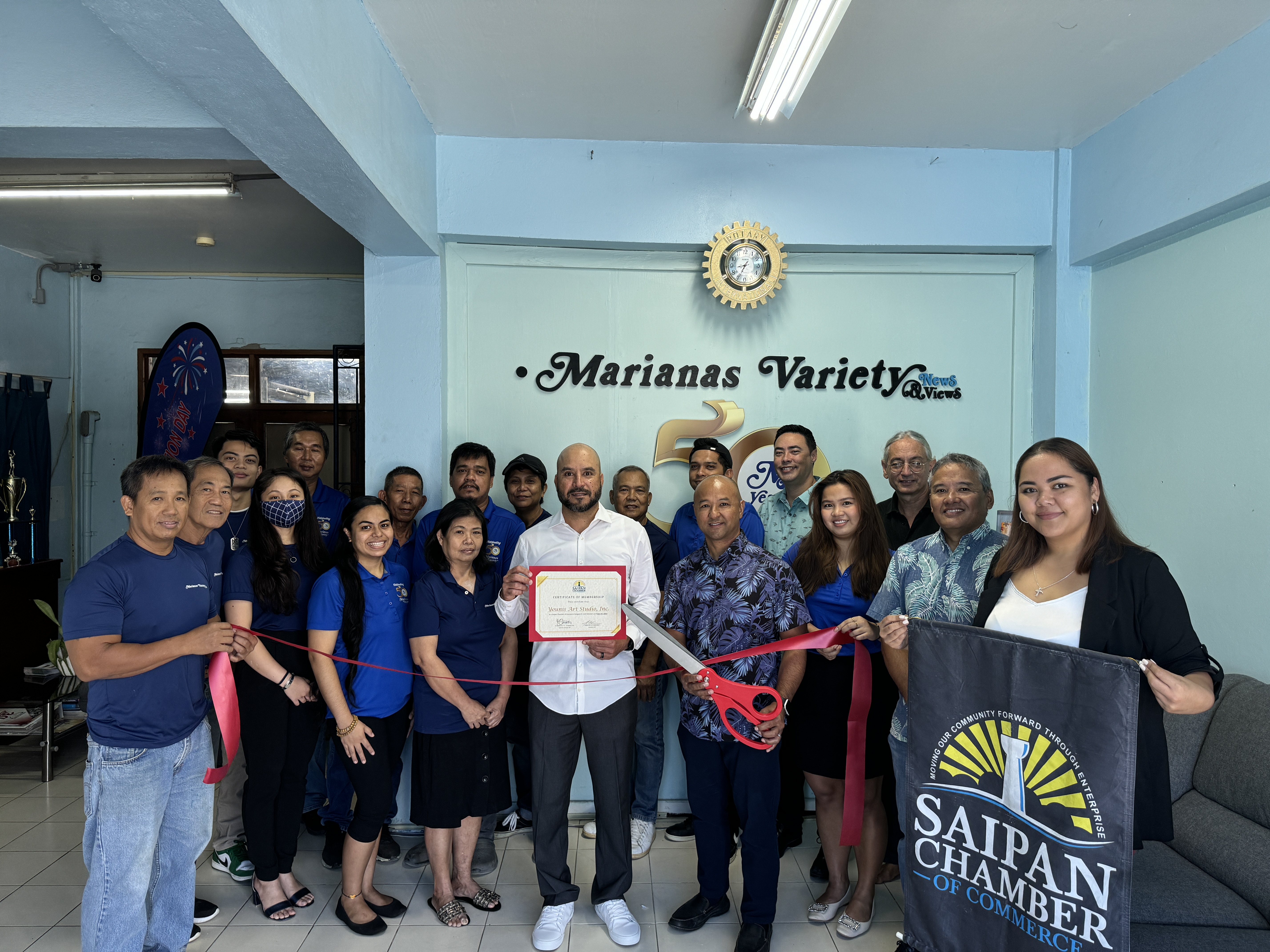 Amier C. Younis, center, president of Younis Art Studio dba Marianas Variety, and his team join the SCC leadership for a ceremonial ribbon-cutting as a returning member.