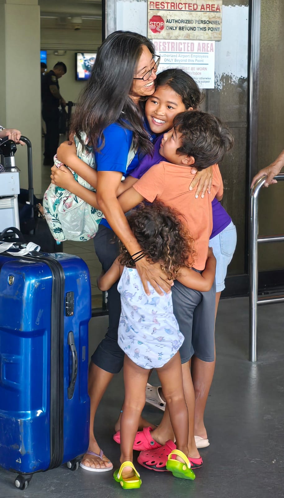 Beach volleyball player Kathy Winkfield is greeted by her children Sunday in the arrival area of the Francisco C. Ada/Saipan International Airport.