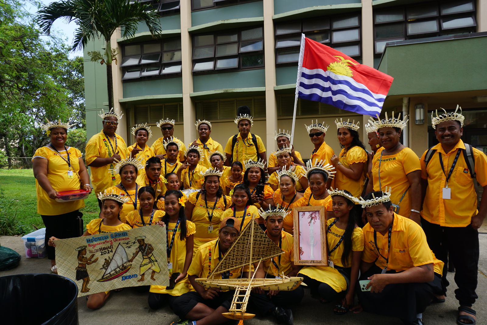 Kiribati ​delegation members pose for a photo with a model canoe and other gifts they brought for Hawaii.