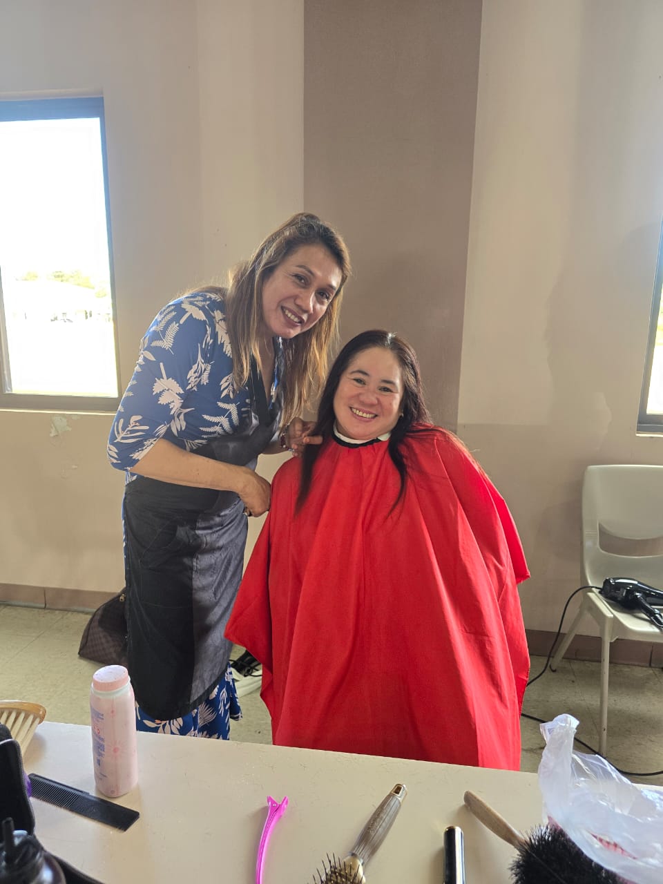 Mommyla Spa & Salon’s Sharmaine Casquero gives Ana Flores a new haircut at the Daidai Social Hall on Sunday.