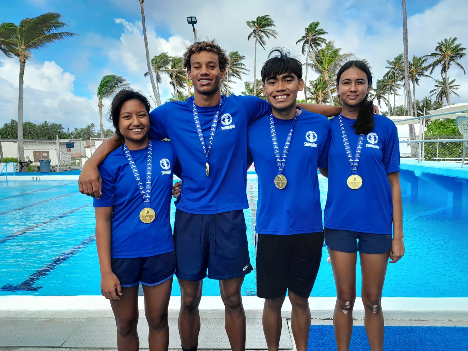 NMI swimmers Maria Batallones, Isaiah Aleksenko, Kean Pajarillaga, and Frances Raho pose for a photo with their medals.
