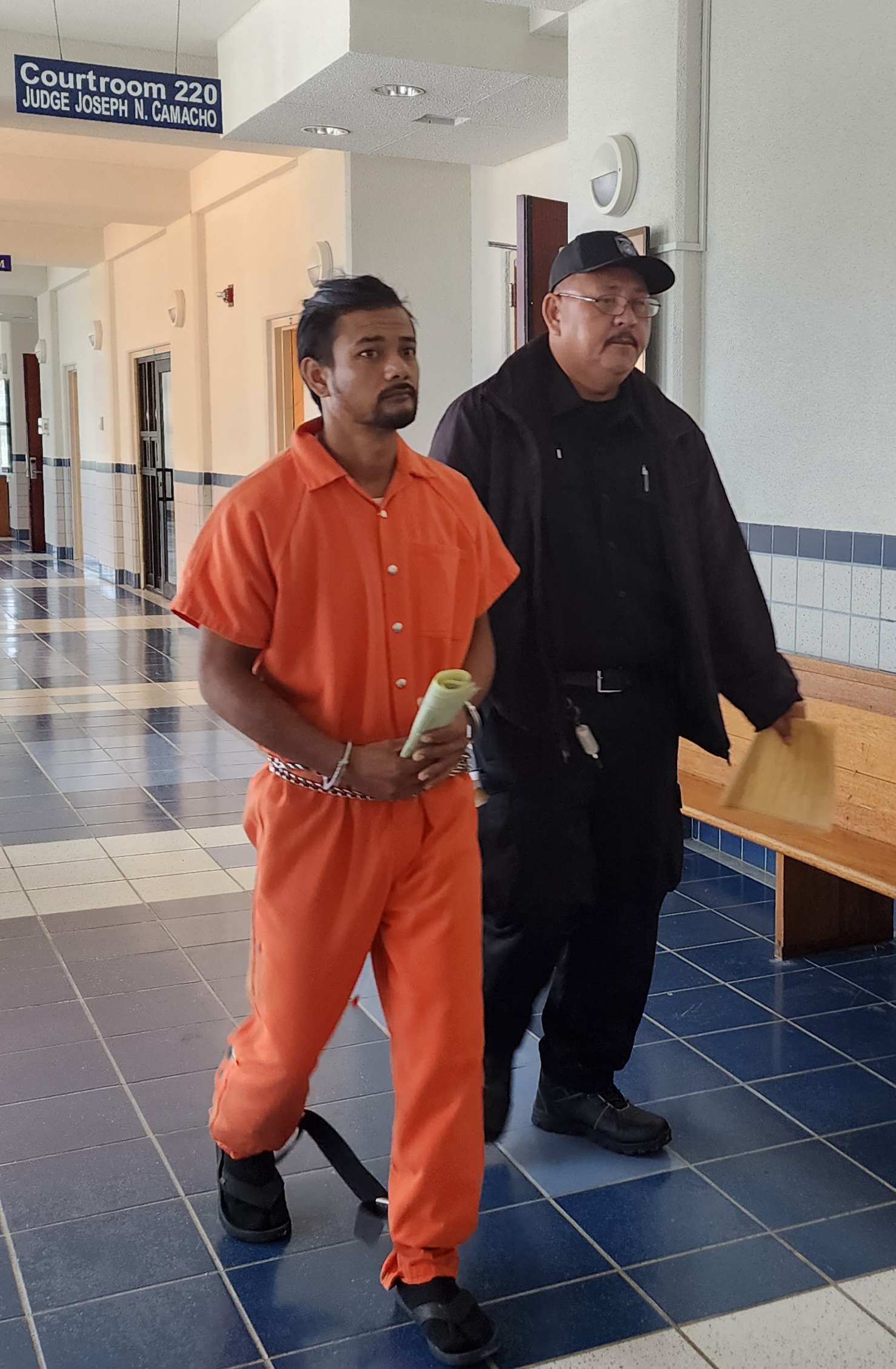 Travis Villagomez is escorted by a Corrections officer following a hearing in Superior Court Thursday morning.