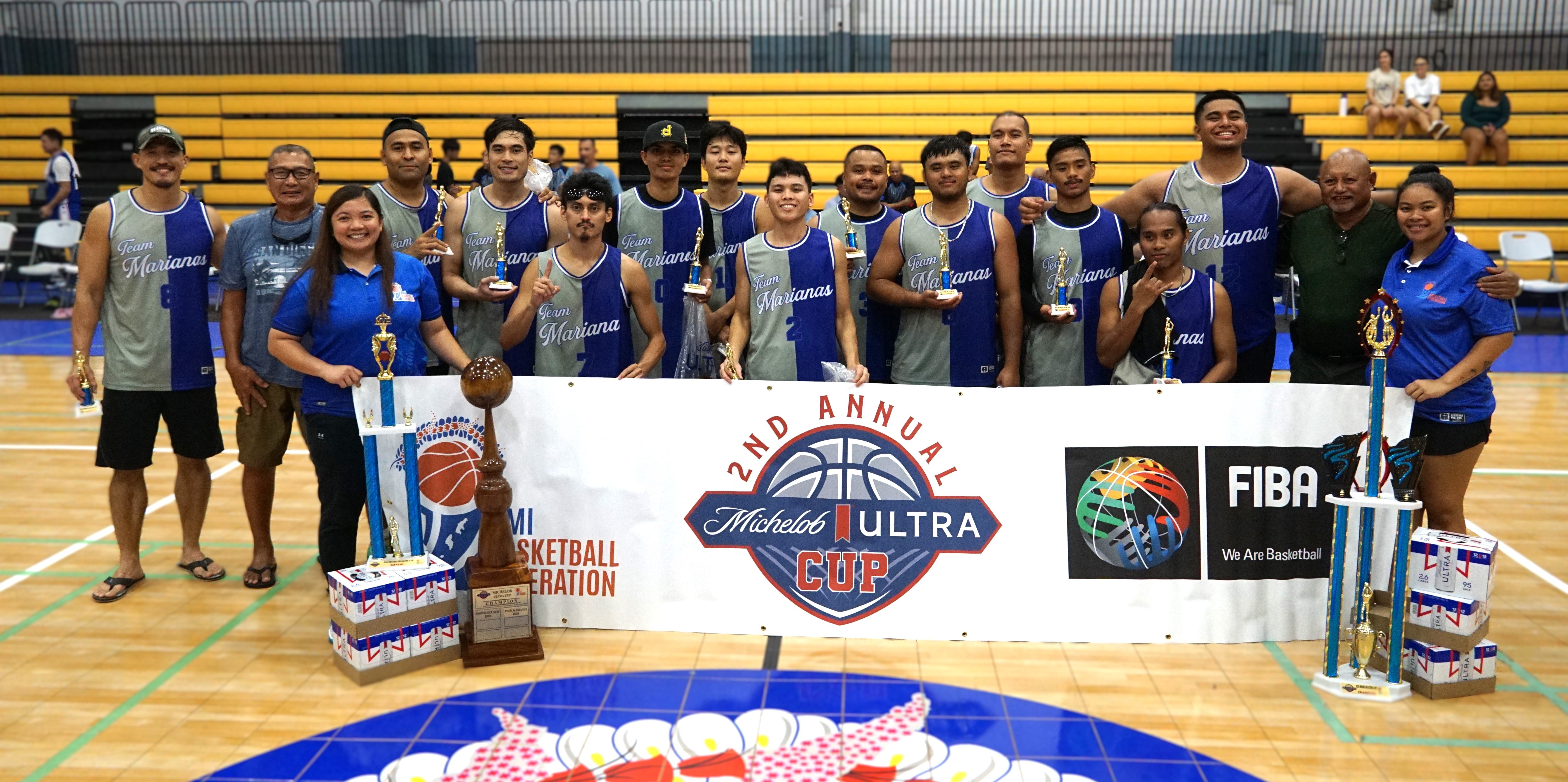 Members of the Team Marianas pose with the Michelob Ultra Cup championship trophy at the Ada gym on Saturday.