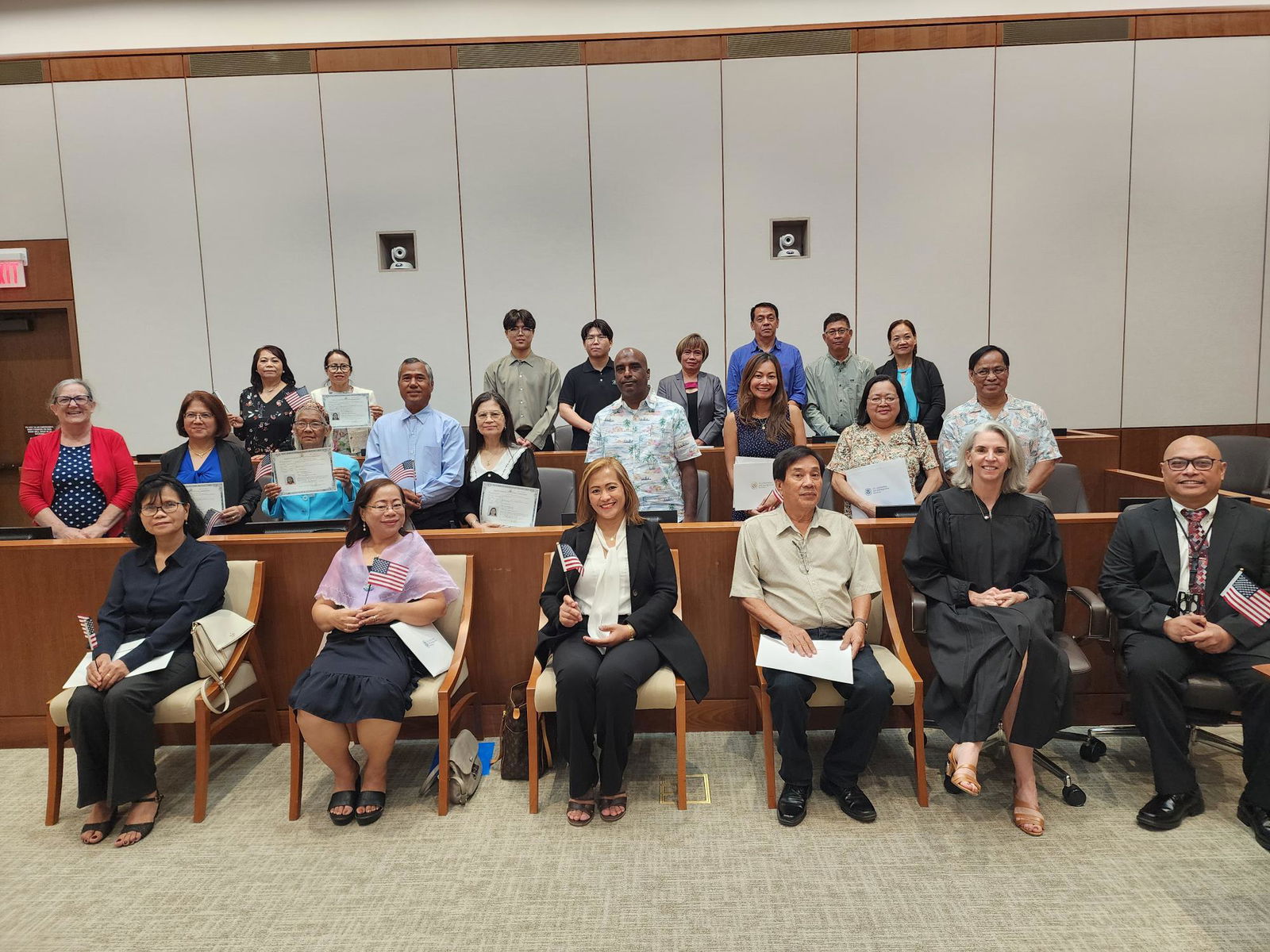 The 20 new U.S. citizens pose for a photo with District Court for the NMI Magistrate Judge Heather Kennedy, District Court IT security officer Dr. Jonathan Liwag and U.S. Citizenship and Immigration Services Officer Patricia Phelan. 