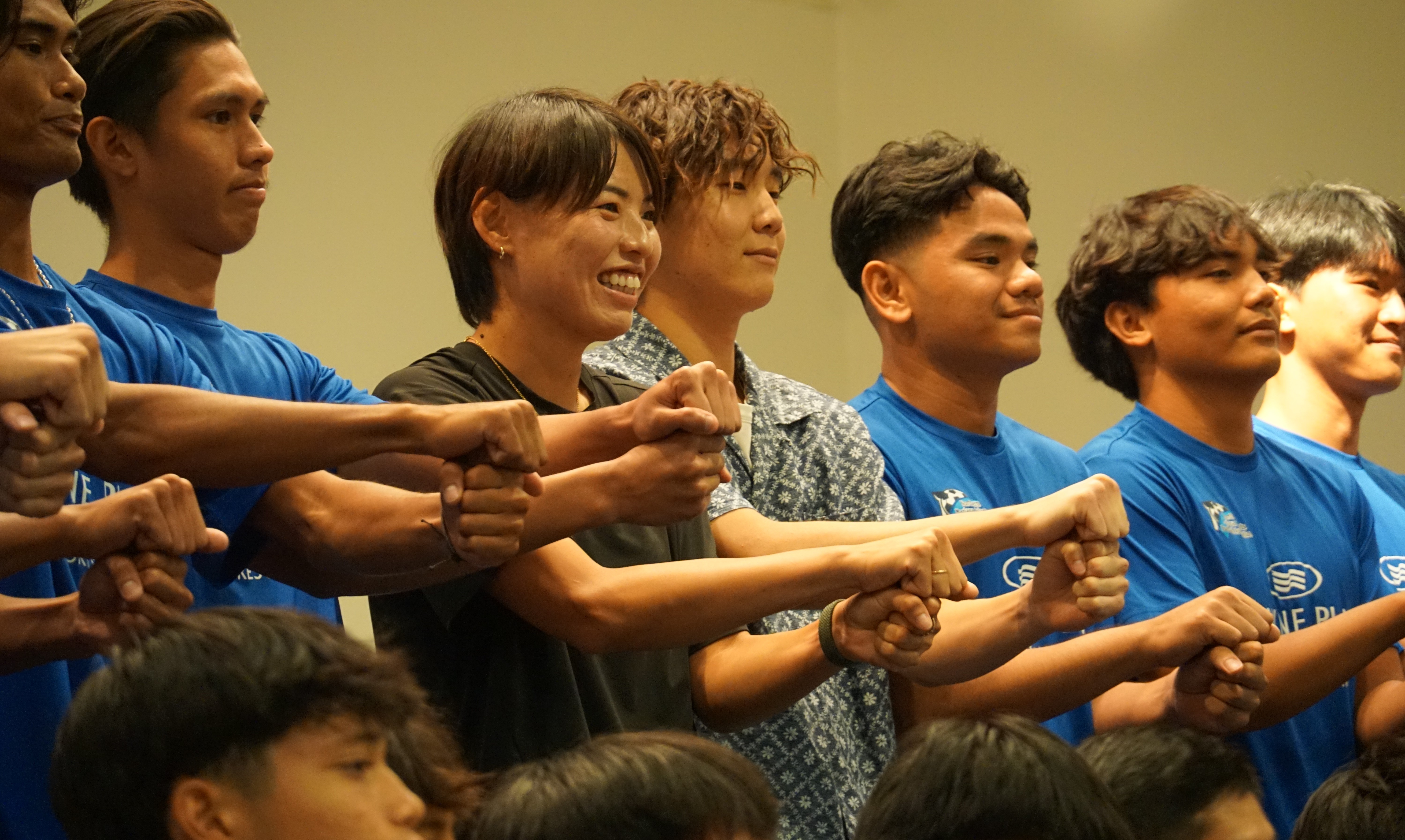 Saki Kumagai poses with the NMI Men's National Team after her presentation in the Hibiscus Hall of Crowne Plaza Resort Saipan on Friday.