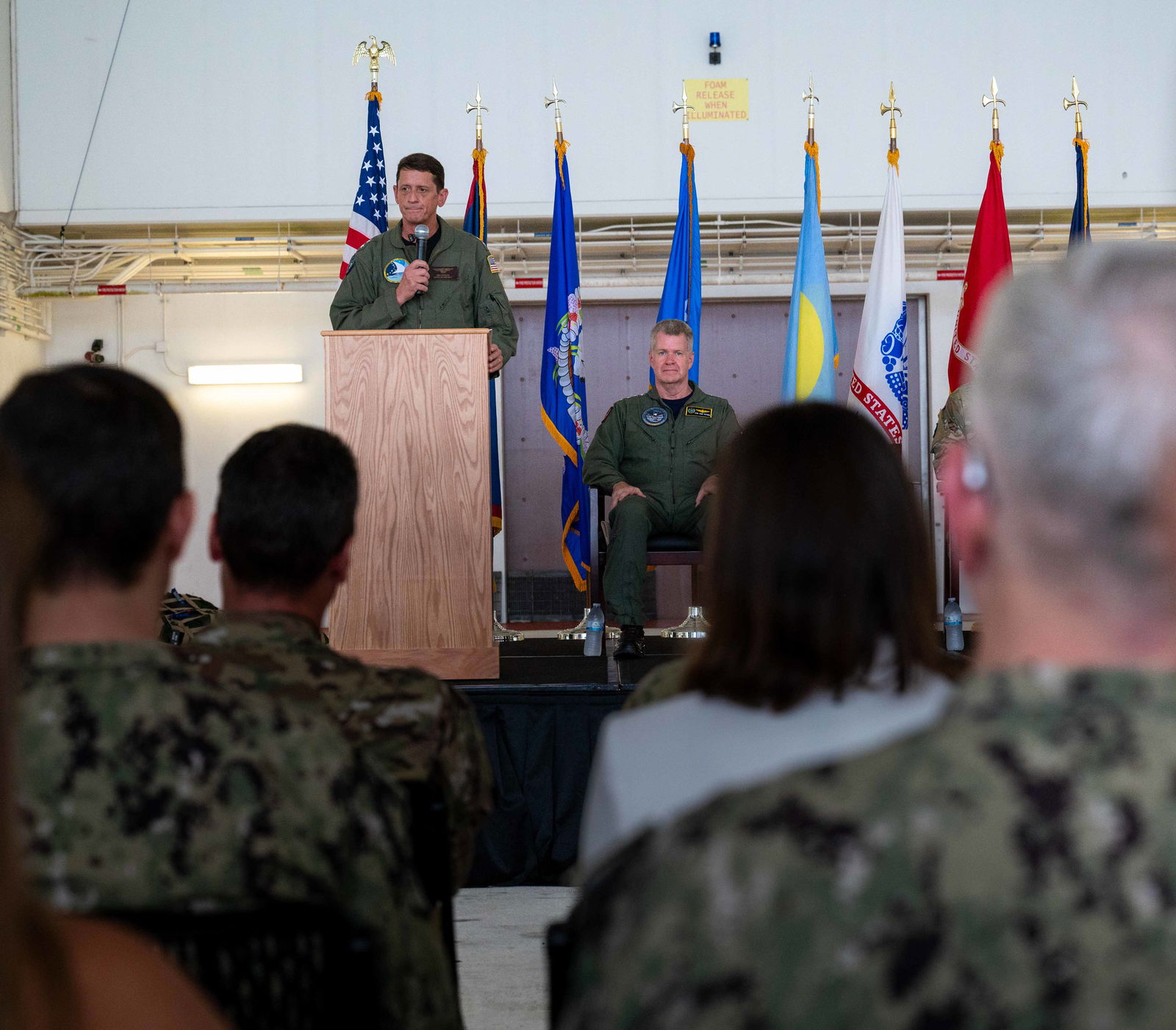Rear Adm. Gregory Huffman delivers remarks while Adm. Samuel Paparo, head of U.S. Indo-Pacific Command, listens during the Joint Task Force–Micronesia assumption-of-command ceremony at Anderson Air Force Base, Guam, June 14, 2024.