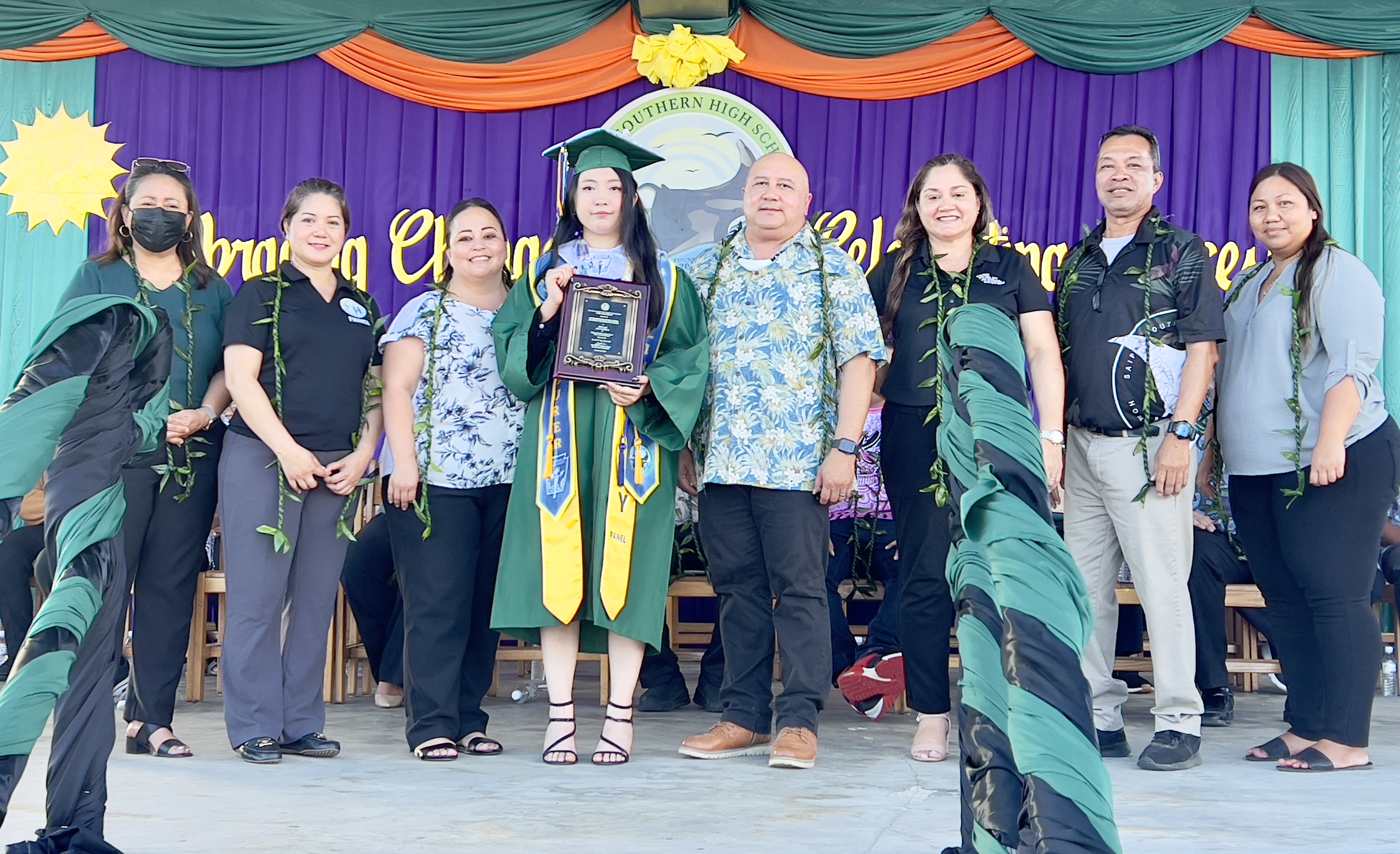 Class salutatorian Jing Lin received the Commissioner of Education Academic Achievement Award, from Commissioner of Education Dr. Lawrence F. Camacho. Also in photo are Special Education Program State Director Donna M. Flores, Senior Director Dr. Yvonne Reyes, Finance Director Arlene Lizama, Human Resource Director Lucretia Deleon Guerrero, Head Start Director Lathania Angui, and Principal Vince Dela Cruz.