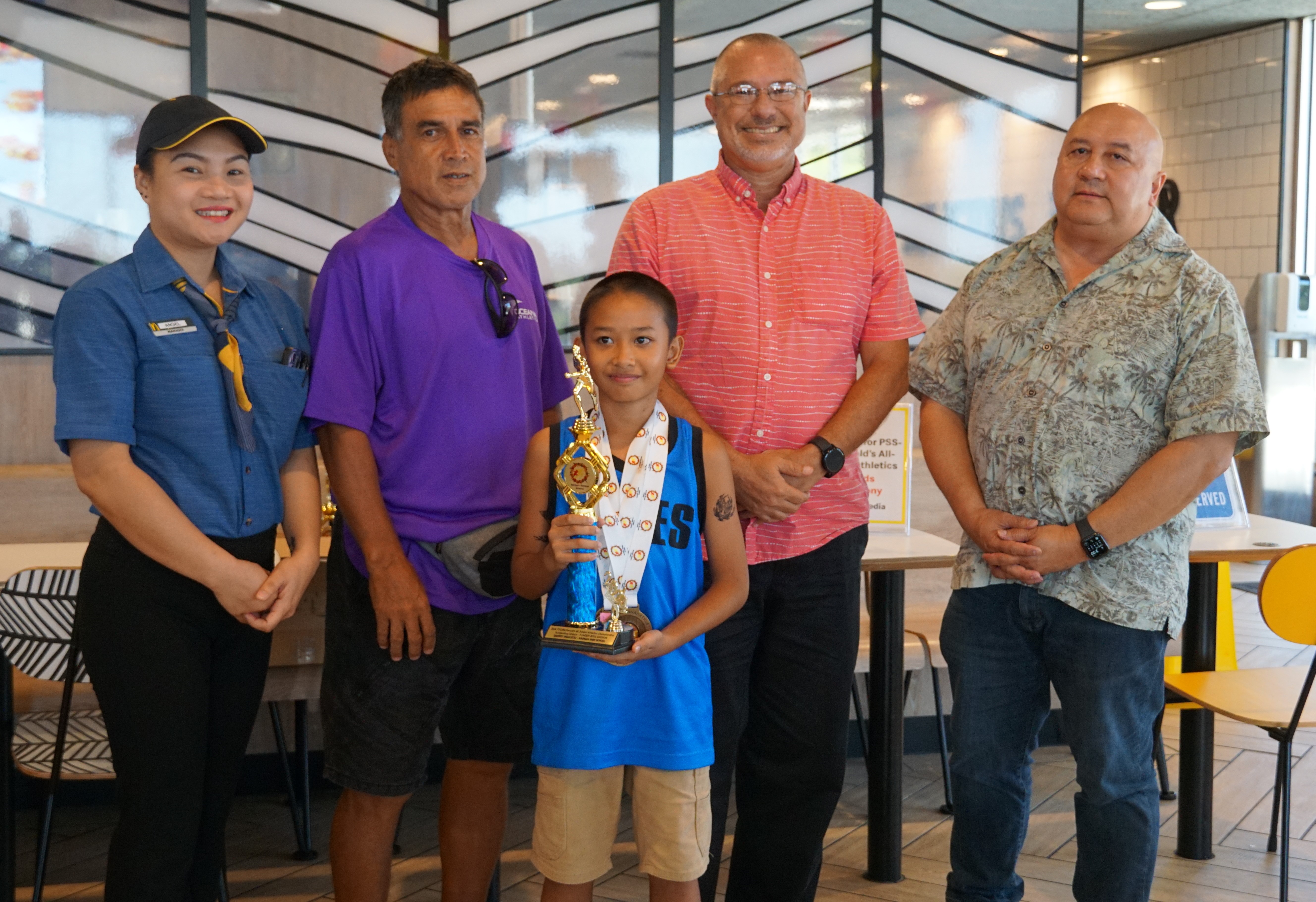 U9 male MVP Davirey Indalecio poses with a McDonald's Saipan employee, Northern Marianas Athletics' Elias Rangamar, Board of Education member Greg Borja and Education Commissioner Dr. Lawrence F. Camacho during the awards ceremony of the McDonald's-PSS All Schools Track and Field (Athletics) SY23-24 awards ceremony at McDonald's Chalan Kiya on Thursday last week.