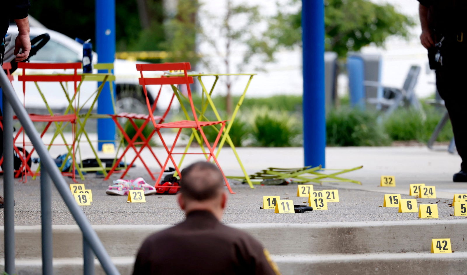 Evidence markers indicate the position of spent shell casings following a mass shooting at the Brooklands Plaza Splash Pad in Rochester Hills, Michigan, June 15, 2024. 