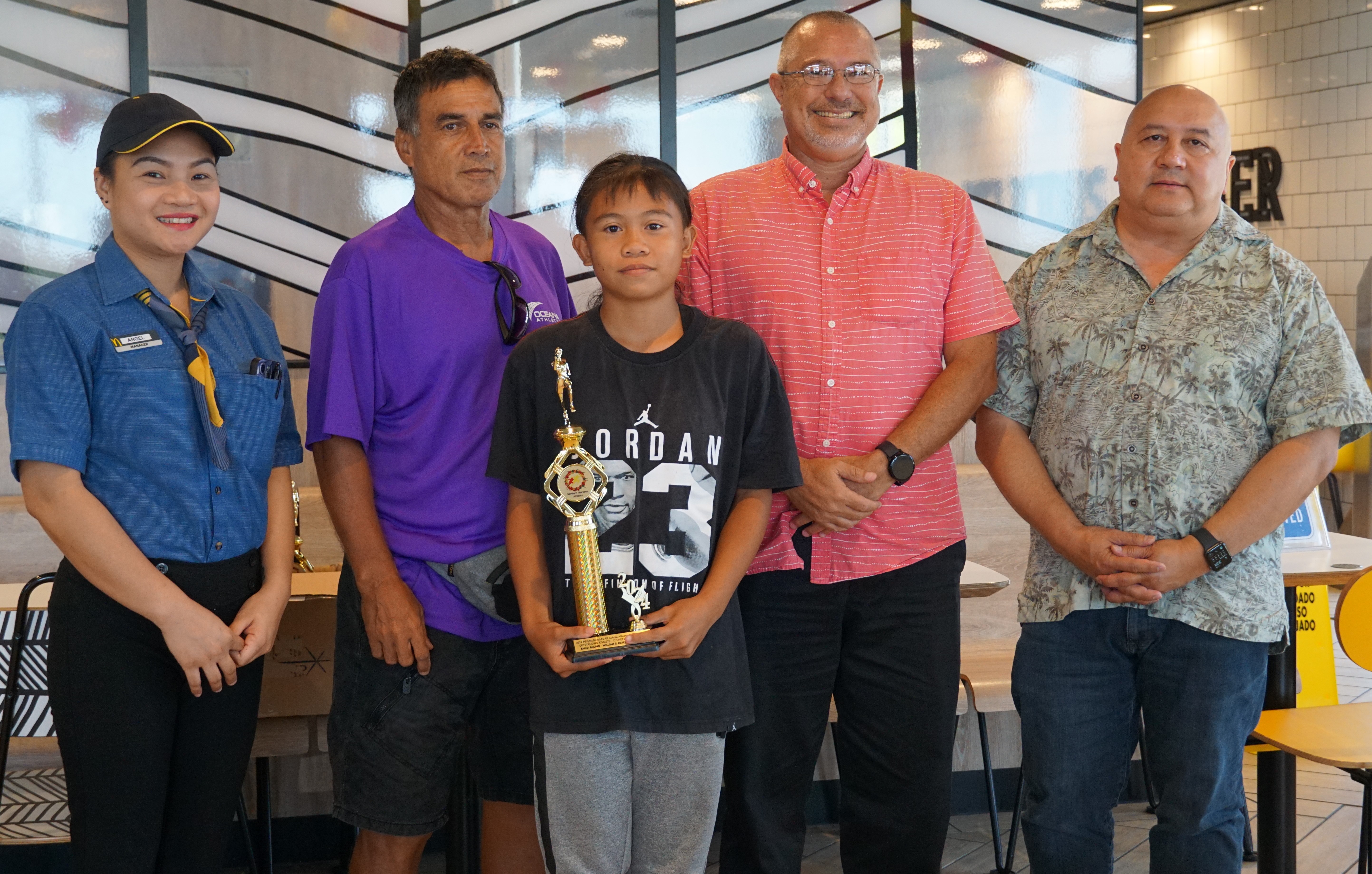U12 female MVP Anica Aquino poses with a McDonald's Saipan employee, Northern Marianas Athletics' Elias Rangamar, Board of Education member Greg Borja and Education Commissioner Dr. Lawrence F. Camacho during the awards ceremony of the McDonald's-PSS All Schools Track and Field (Athletics) SY23-24 awards ceremony at McDonald's Chalan Kiya on Thursday last week.