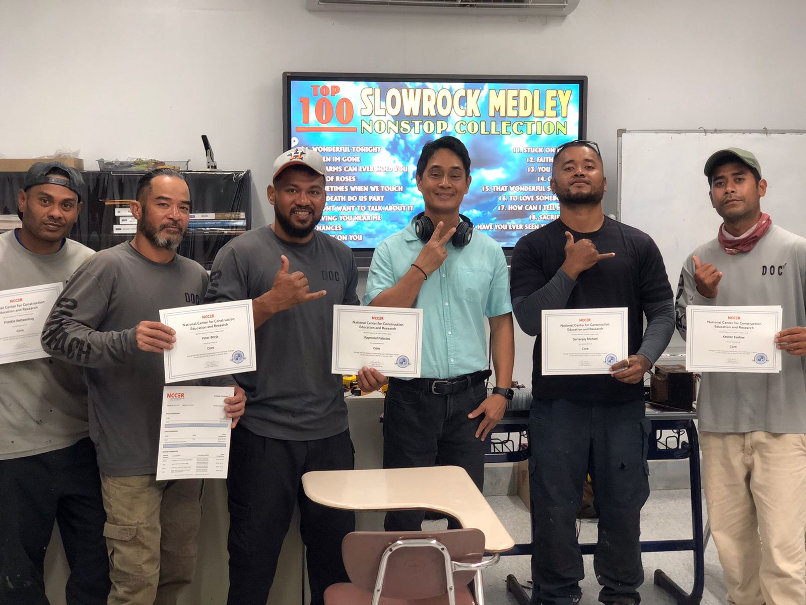 Department of Corrections Outreach Program participants display their certifications as they pose for a photo with their instructor.