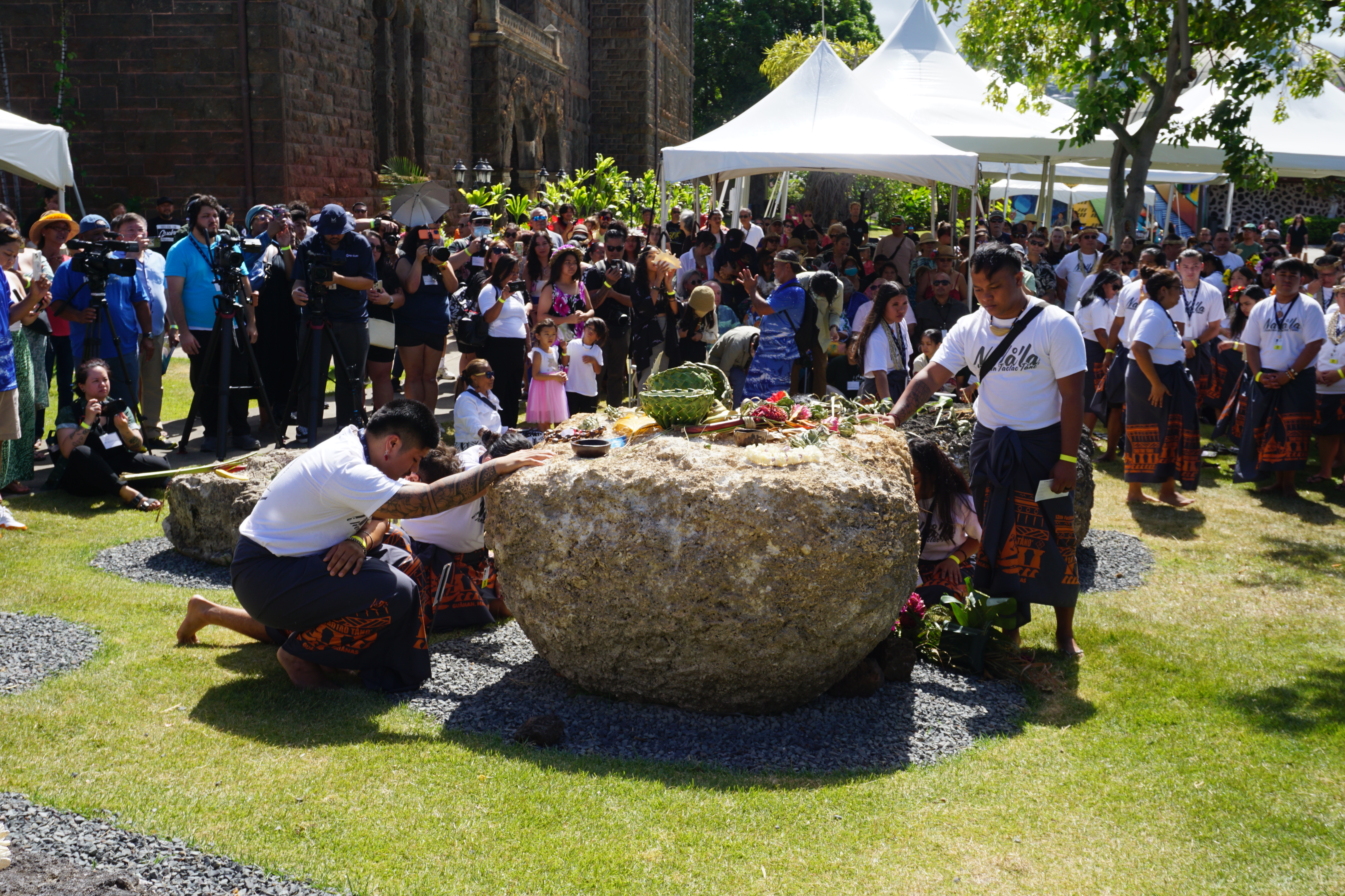 Participants touch the latte stones during the ceremony.