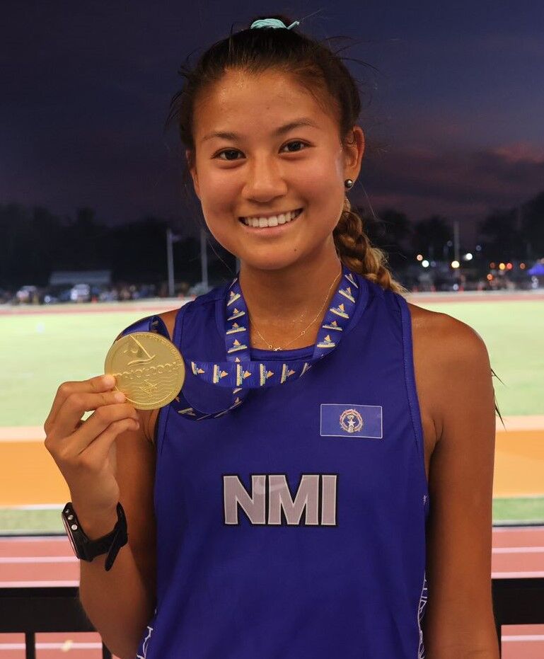 Tania Tan proudly shows her gold medal in the 5,000m race.