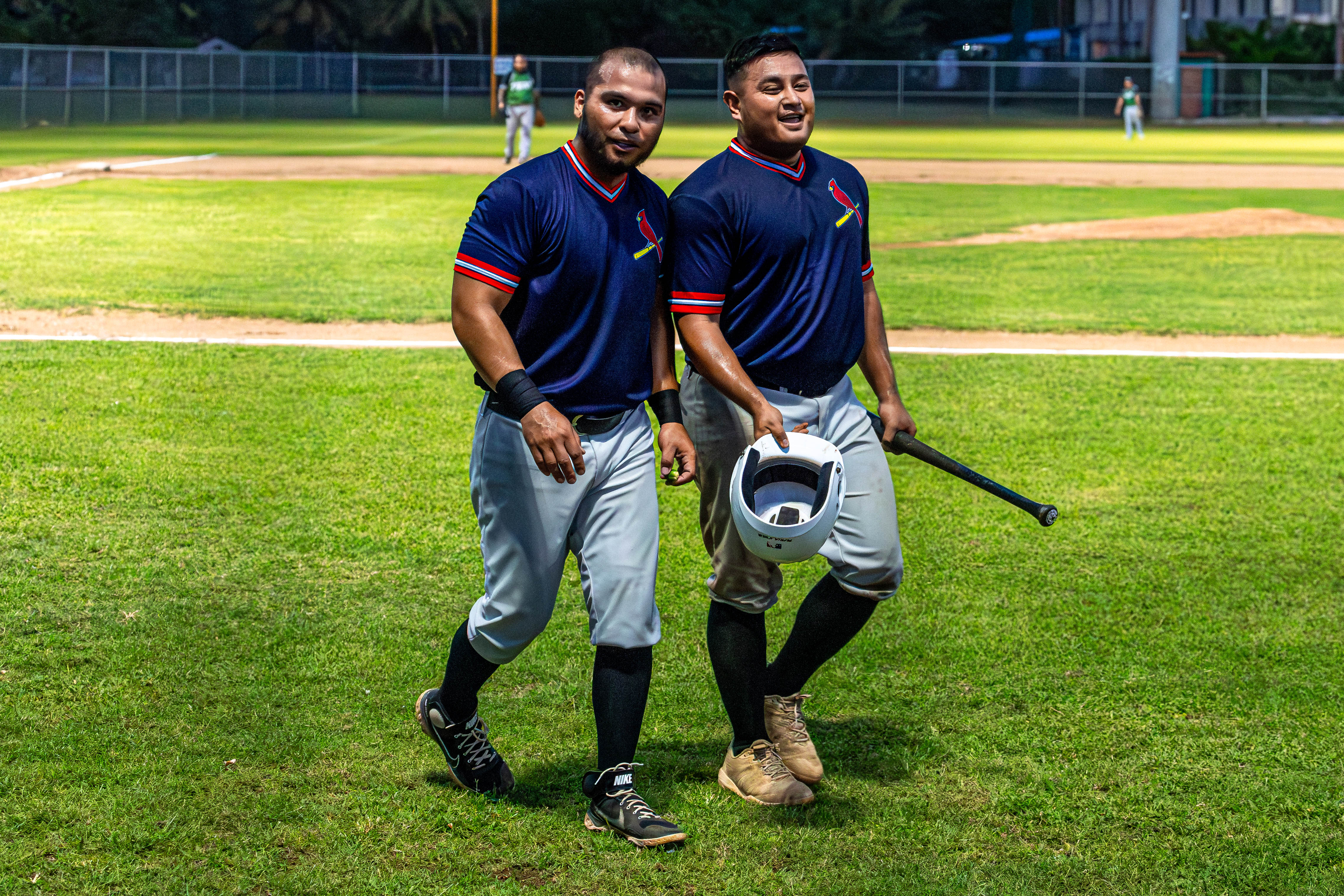 The Cardinals' #52 Tenorio, left, and #9 Saralu celebrate as they both run in for two runs on one hit.