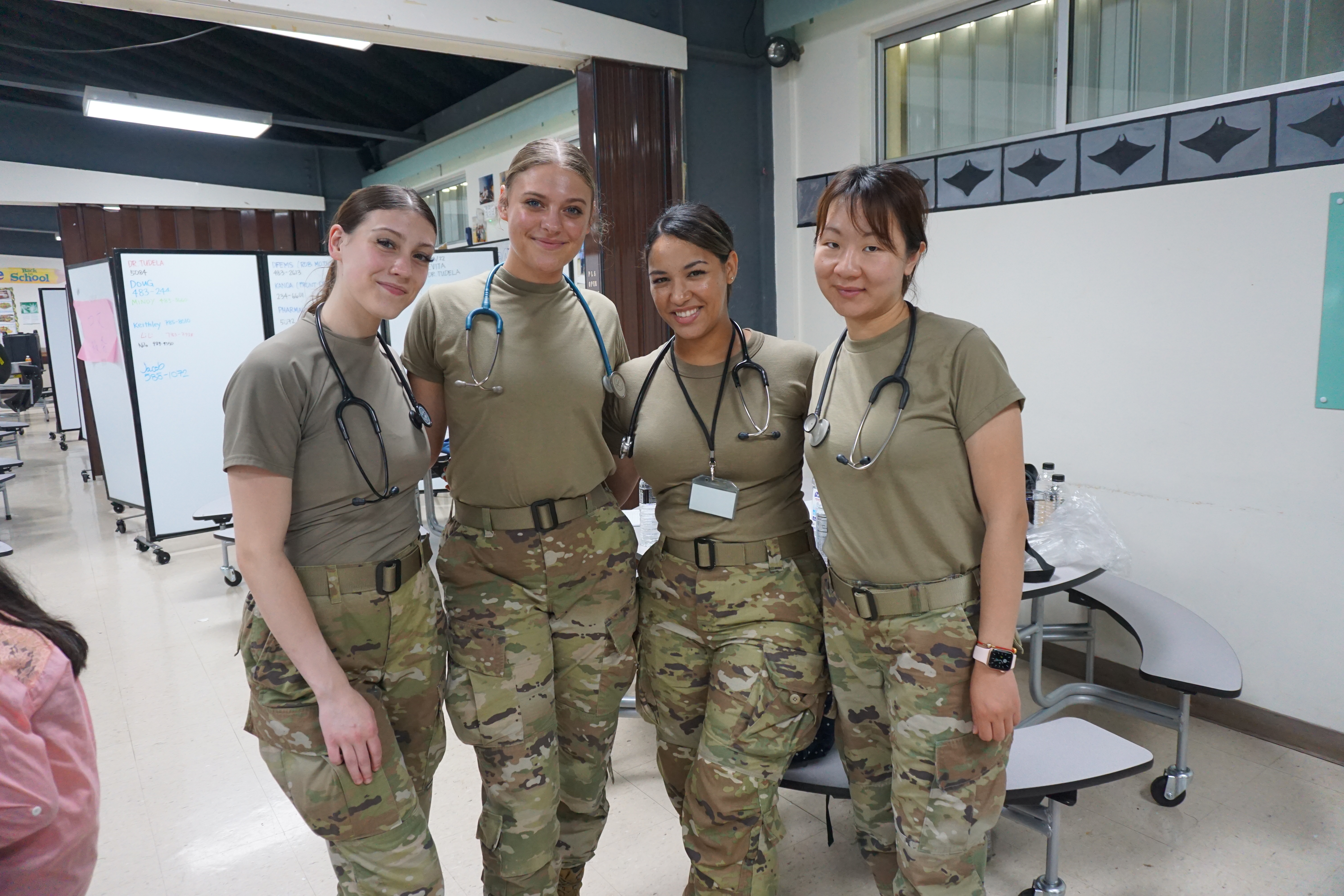 From left, Senior Airman Sierra Long, Airforce Airman 1st Class Hannah Wolverton, 2nd Lt. Bernadette Rivera, and Staff Sgt, Yao Cai pose for a photo in the Saipan Southern High School cafeteria.