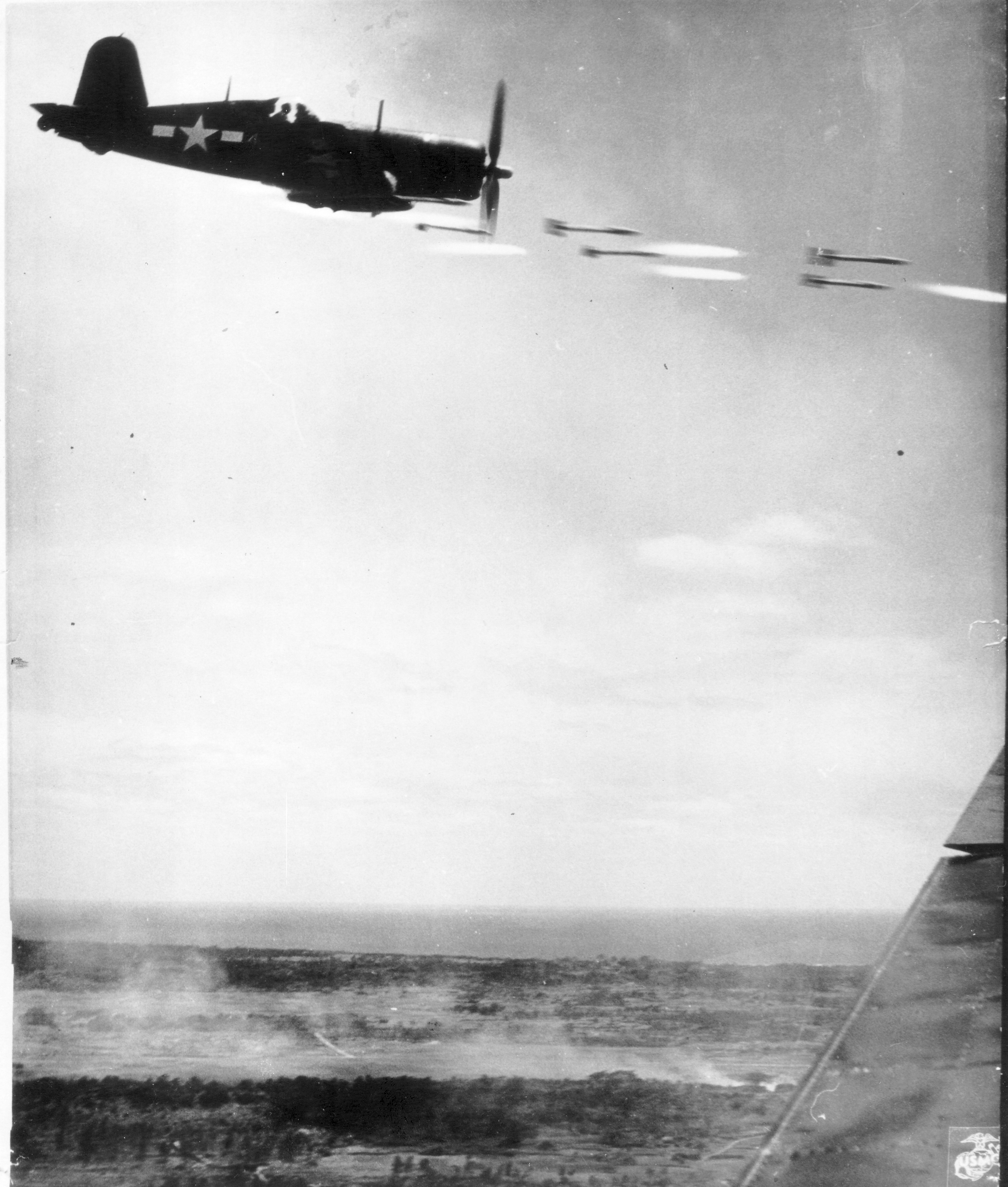 A Marine fighter fires rockets.