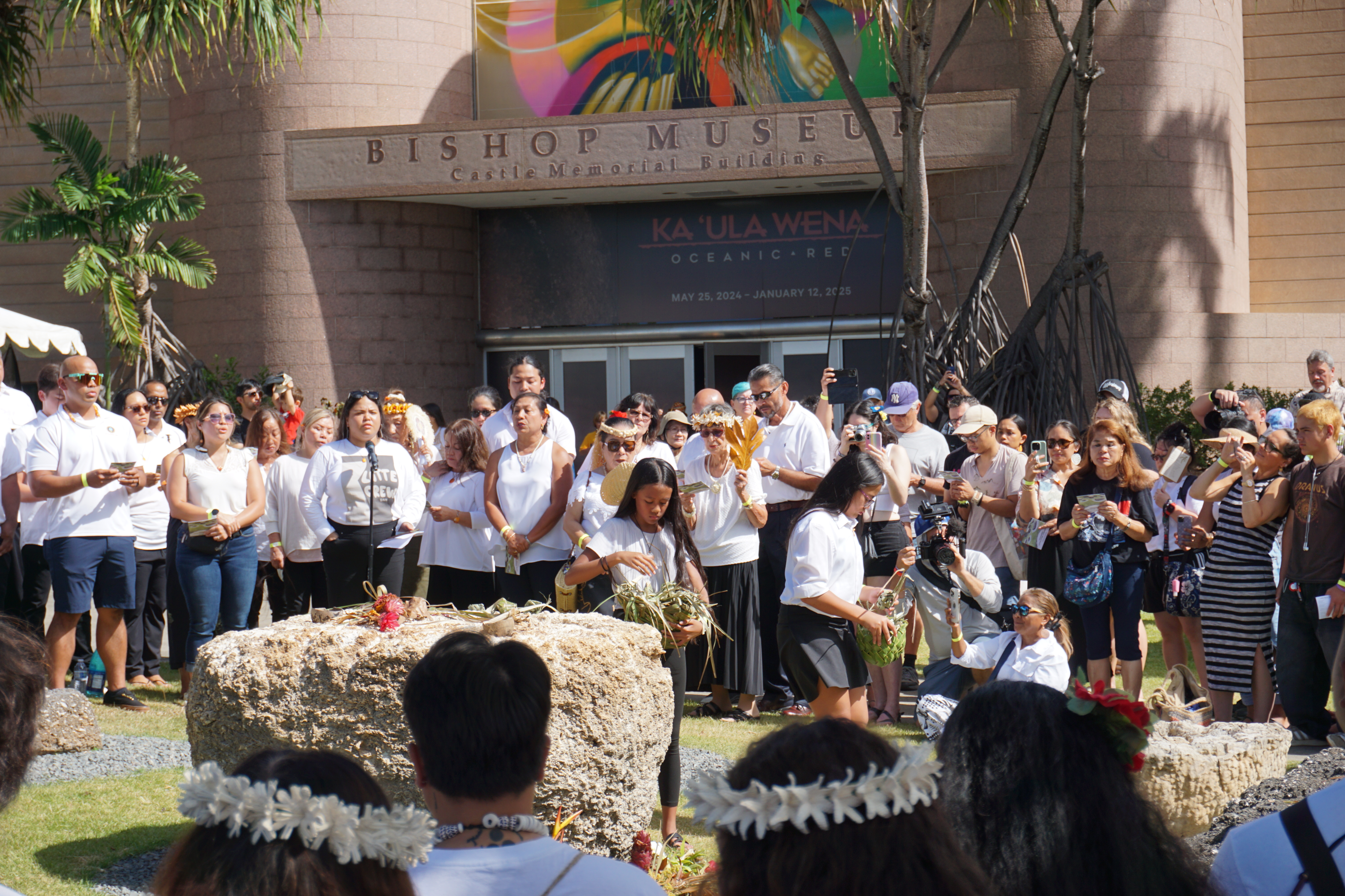 Youth participants lay offerings on the latte stones.