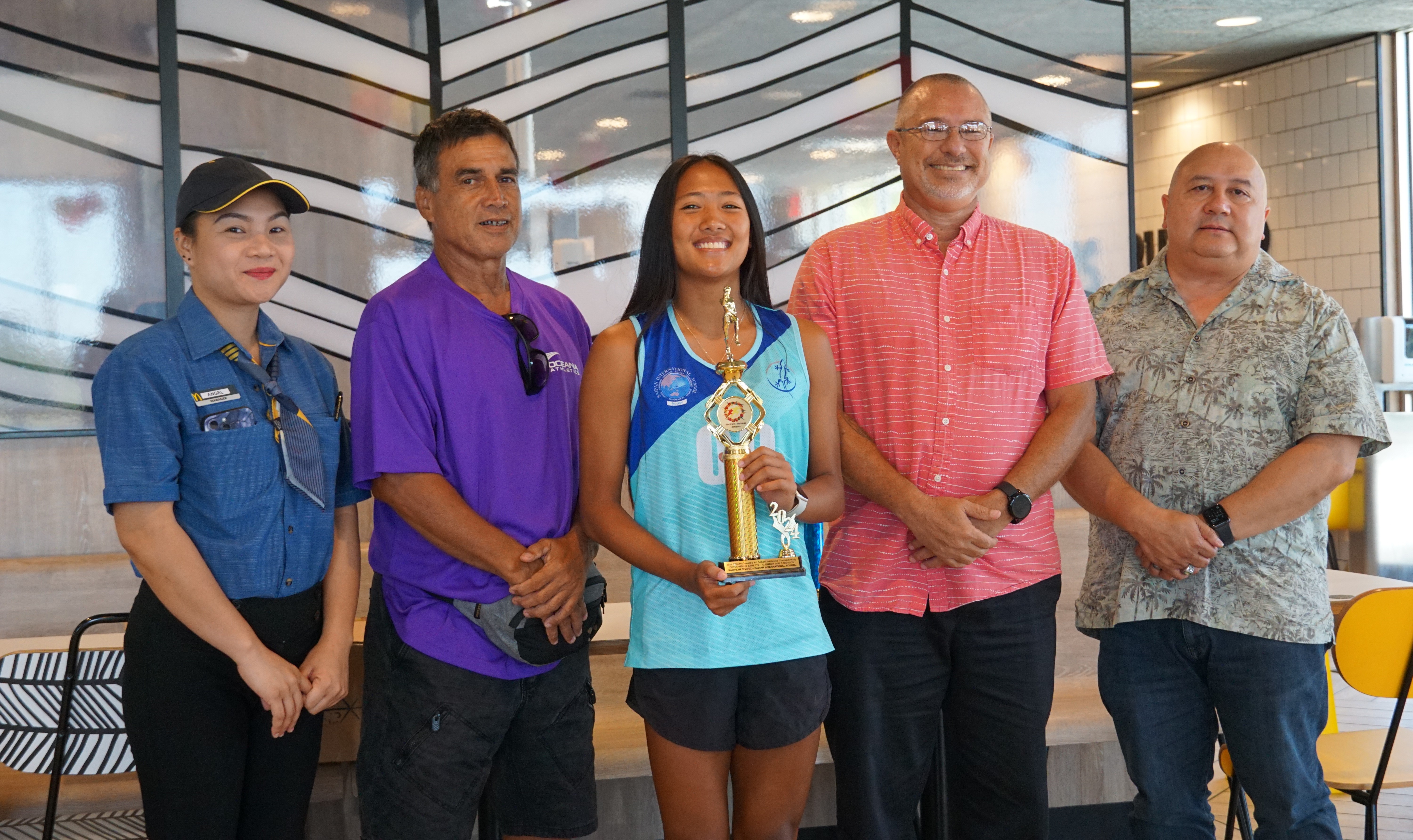 U18 female MVP Kaithlyn Chavez, center, poses for a photo with a McDonald's Saipan employee, Northern Marianas Athletics' Elias Rangamar, Board of Education member Greg Borja and Education Commissioner Dr. Lawrence F. Camacho during the McDonald's-PSS All Schools Track and Field (Athletics) SY23-24 awards ceremony at McDonald's Chalan Kiya on Thursday last week.