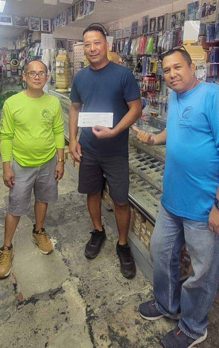 Jorge Bartolata and Jerson Caduduan of Fishing Tackle & Sporting Goods are pictured with Chairman Joseph E. Santos of the 19th Tinian Municipal Council.