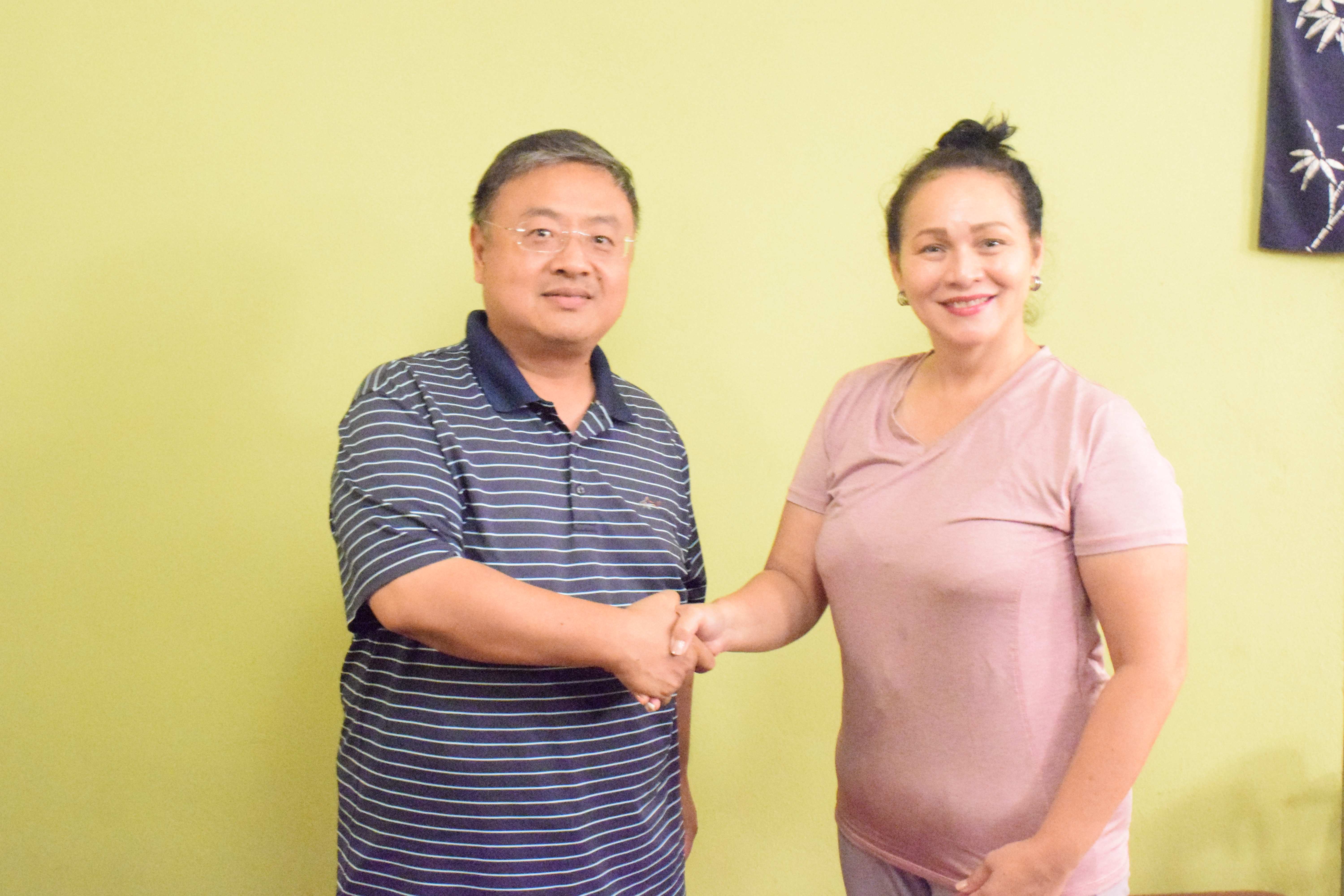 Asia Chamber of America Assistant Director Li Xue and local facilitator Mary Ann Borja shake hands as they pose for Variety.