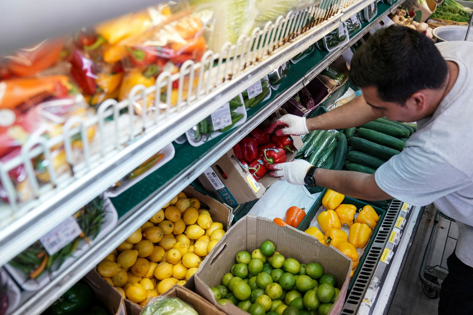 A man arranges produce at Best World Supermarket in the Mount Pleasant neighborhood of Washington, D.C., Aug.19, 2022.