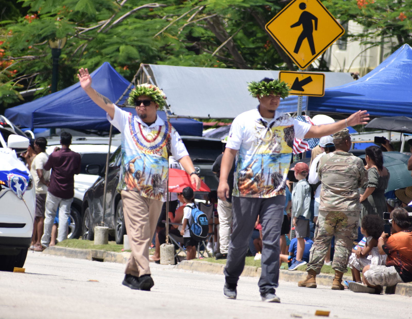Liberation Day Committee Chair Delbert Pua and Vice Chair Edmond H. Borja wave to the crowd during the Fourth of July parade on Beach Road Thursday.