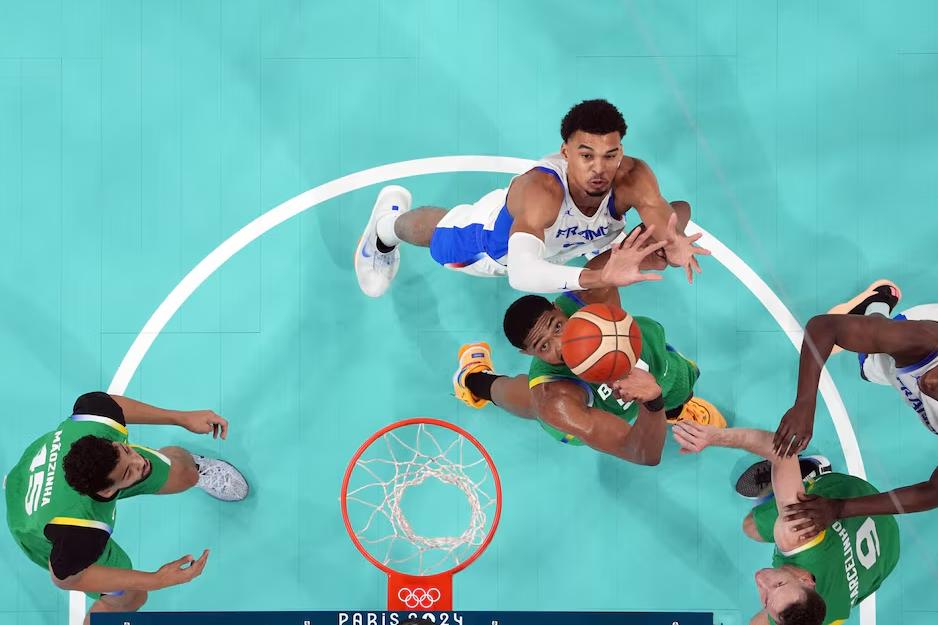Brazil power forward Bruno Caboclo (51) and France power forward Victor Wembanyama (32) reach for the ball during the Paris 2024 Olympic Summer Games at Stade Pierre-Mauroy in Villeneuve-d'Ascq, France, July 27, 2024.