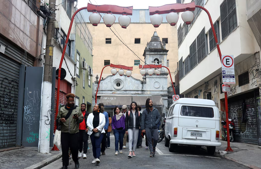 People walk during a tour of Liberdade neighborhood, to learn the Black history of the city arranged by “Guia Negro” an organization that aims to disseminate the Black history of the country in Sao Paulo, Brazil, July 13 2024.