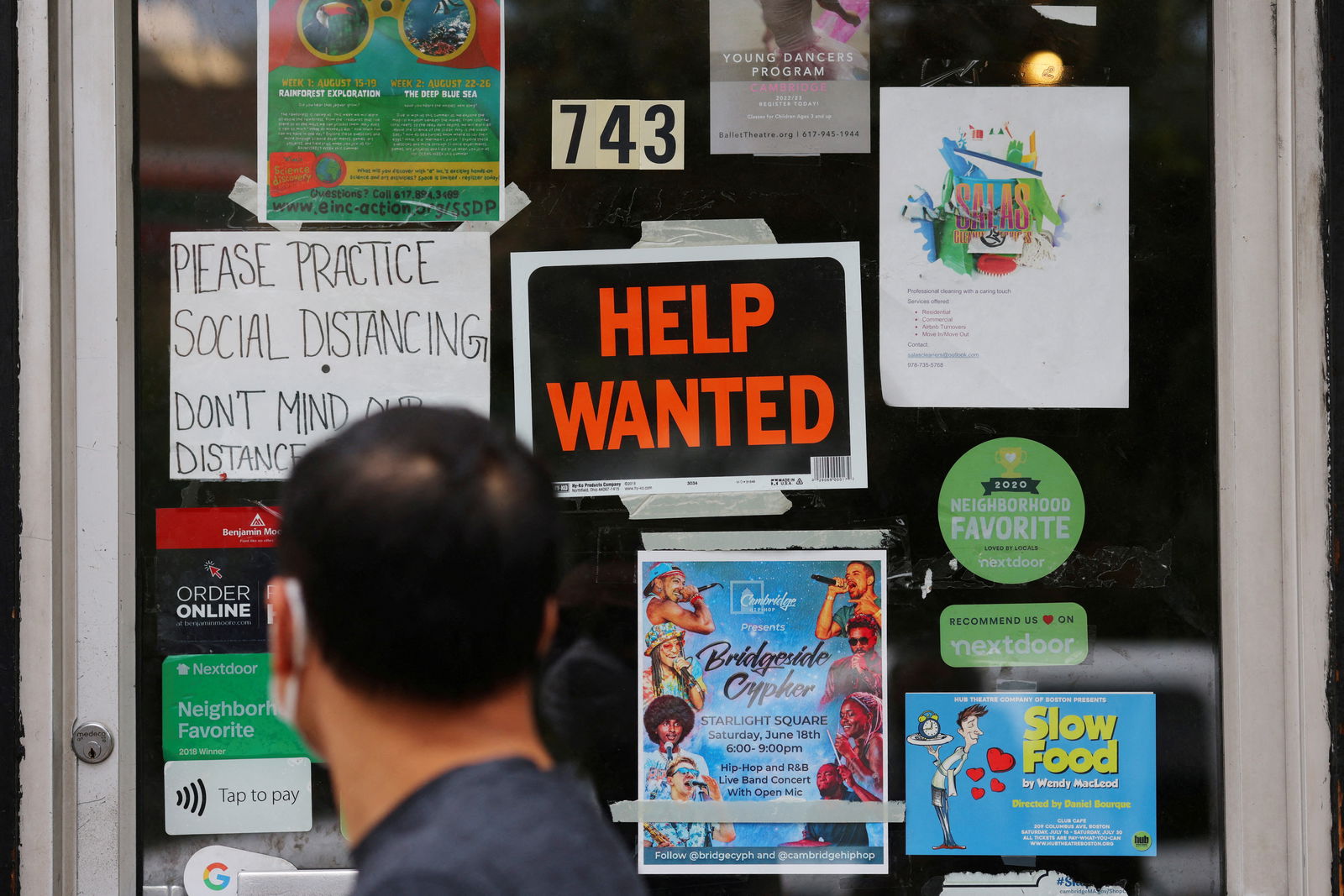 A pedestrian passes a "Help Wanted" sign in the door of a hardware store in Cambridge, Massachusetts, July 8, 2022.