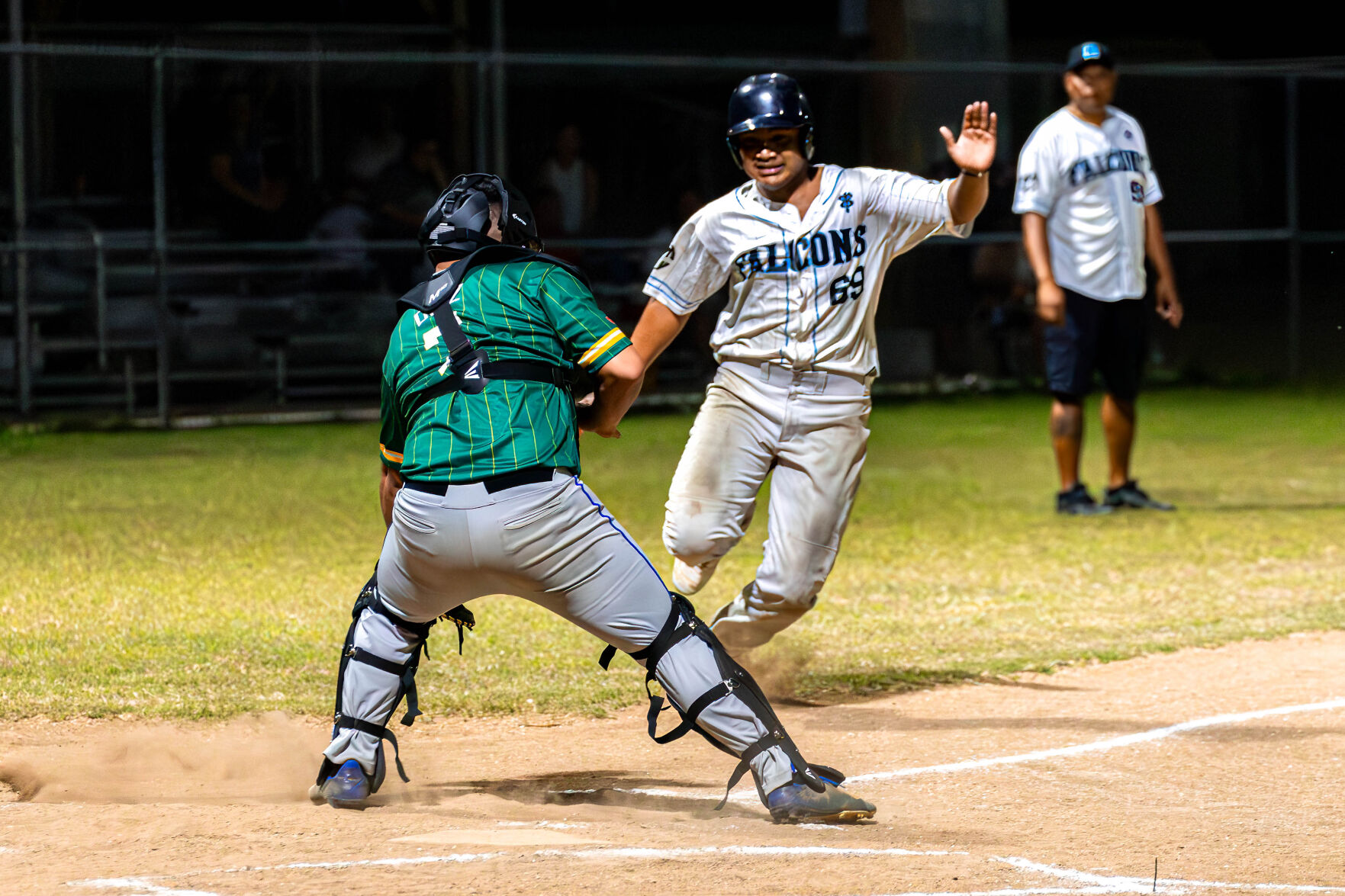 The Falcons' Jonathan Norita attempts to beat the tag as he rushes toward home plate for a scored run during a game against the Sandlot in the 2024 Tan Holdings Saipan Baseball League at the Francisco "Tan Ko" Palacios Baseball Field.