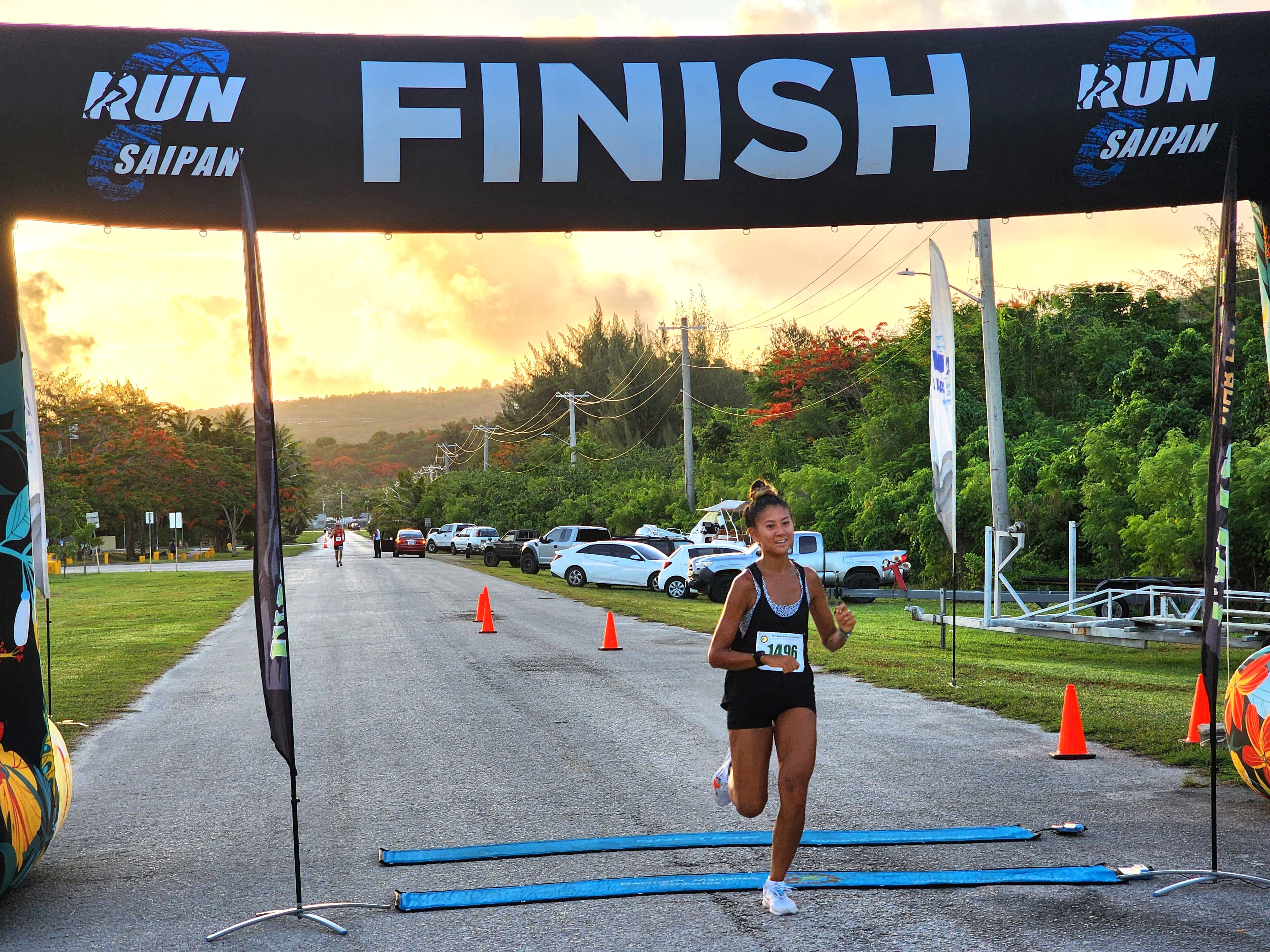 Tania Tan crosses the finish line to top the women's division of Run Saipan’s 4th Annual 4th of July Independence Day 2-mile Race at Smiling Cove Marina on Thursday morning.