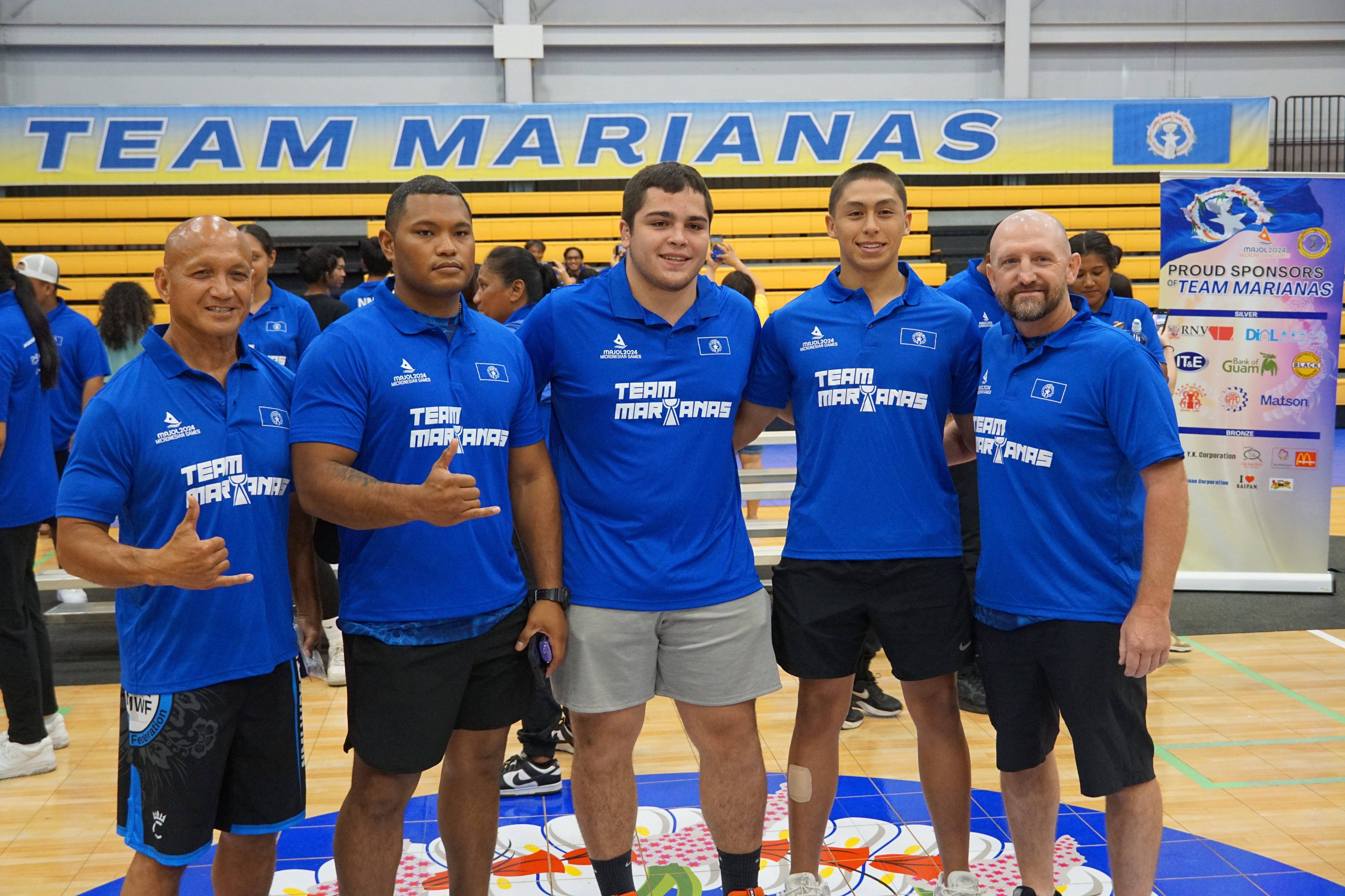Aiden Attao, center, poses with the NMI Men's National Wrestling Team during the Micronesian Games send-off ceremony for Team Marianas at the Ada gym on June 10, 2024.