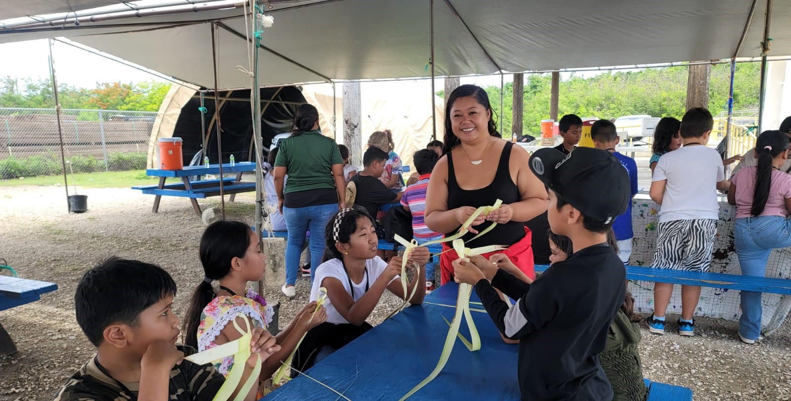 Nicole Tyquiengco teaches coconut frond weaving at the Marianas Tourism Education Council and Marianas Visitors Authority’s outreach in Koblerville on July 24, 2024.