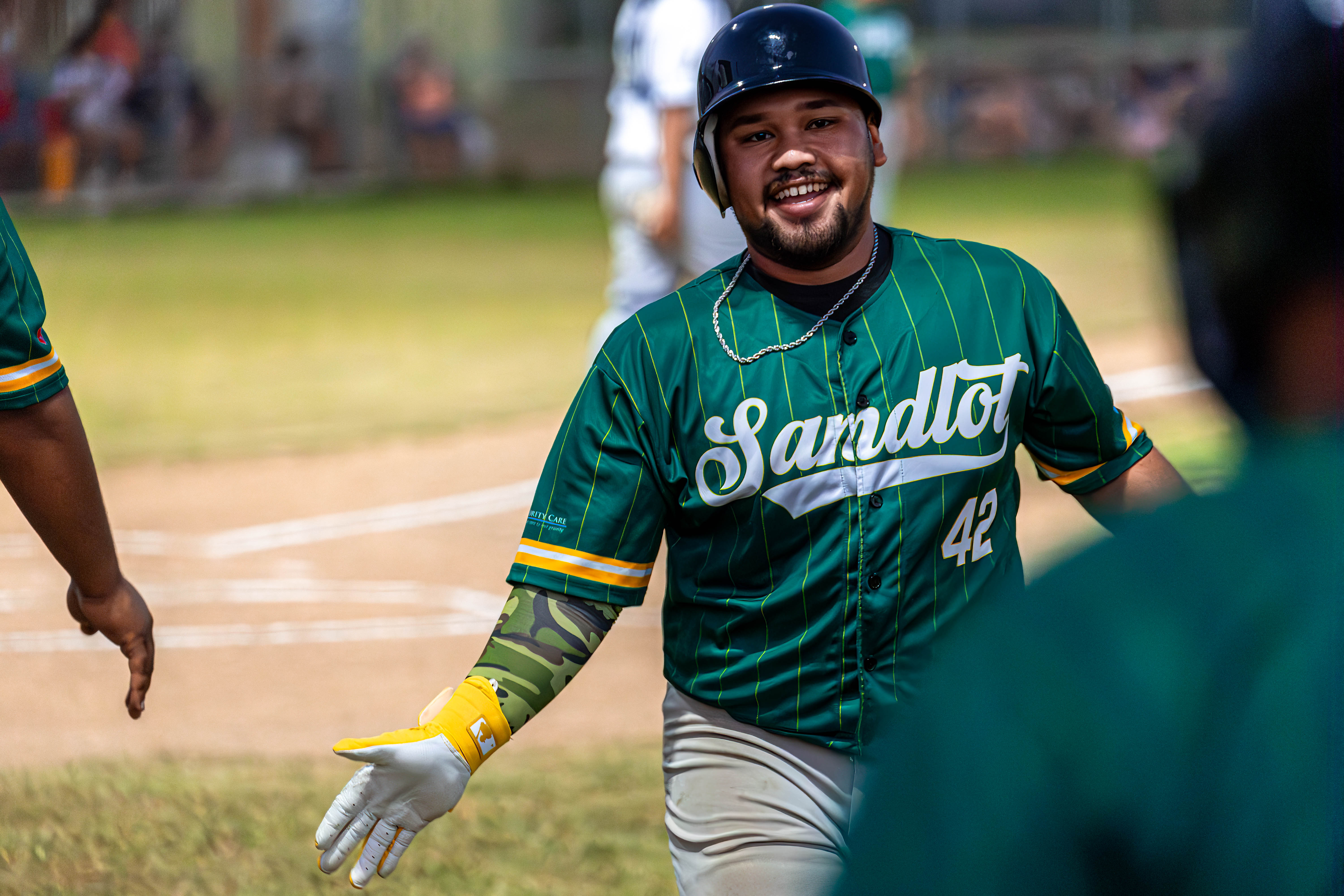 Sandlot's right fielder, Jobe Reyes, high-fives his teammates as he returns to the dugout.