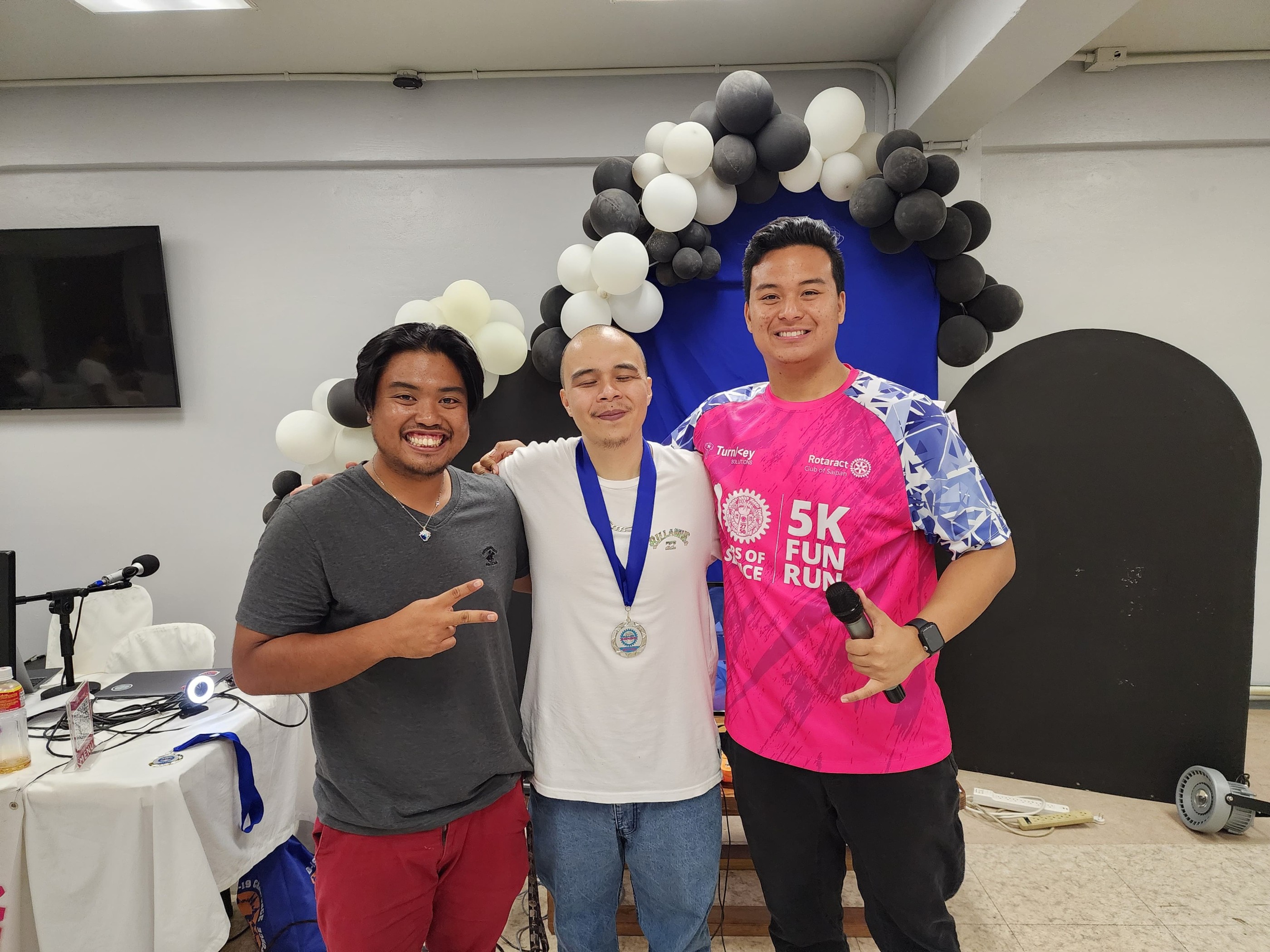 Second place Eric “JR3 2D” Tudela Jr. poses with Rotaract Club of Saipan President Richard Baleares and tournament committee head Simon Necesito.