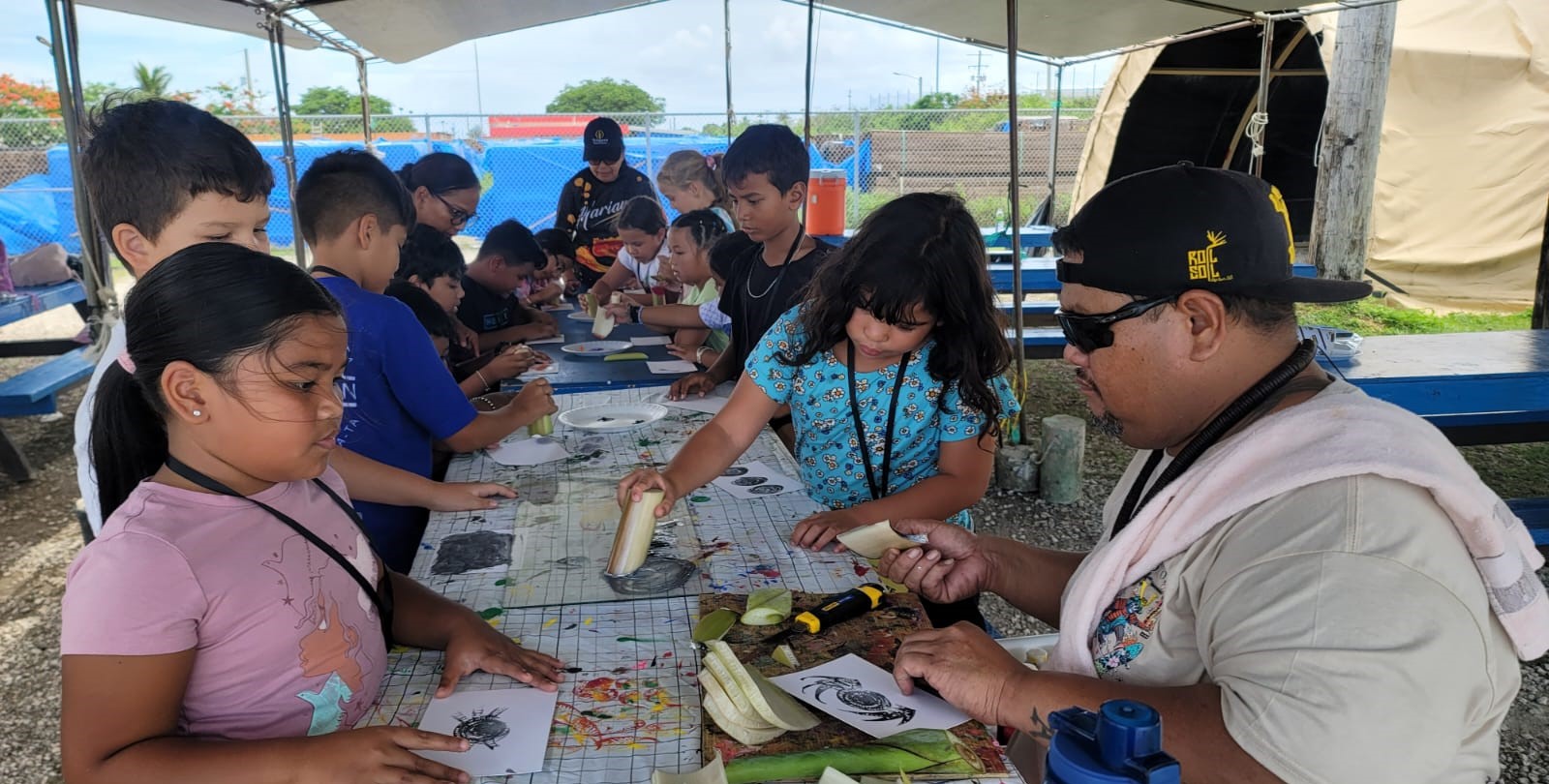 Brian Ruben teaches banana painting at the Marianas Tourism Education Council and Marianas Visitors Authority’s outreach in Koblerville on July 24, 2024.